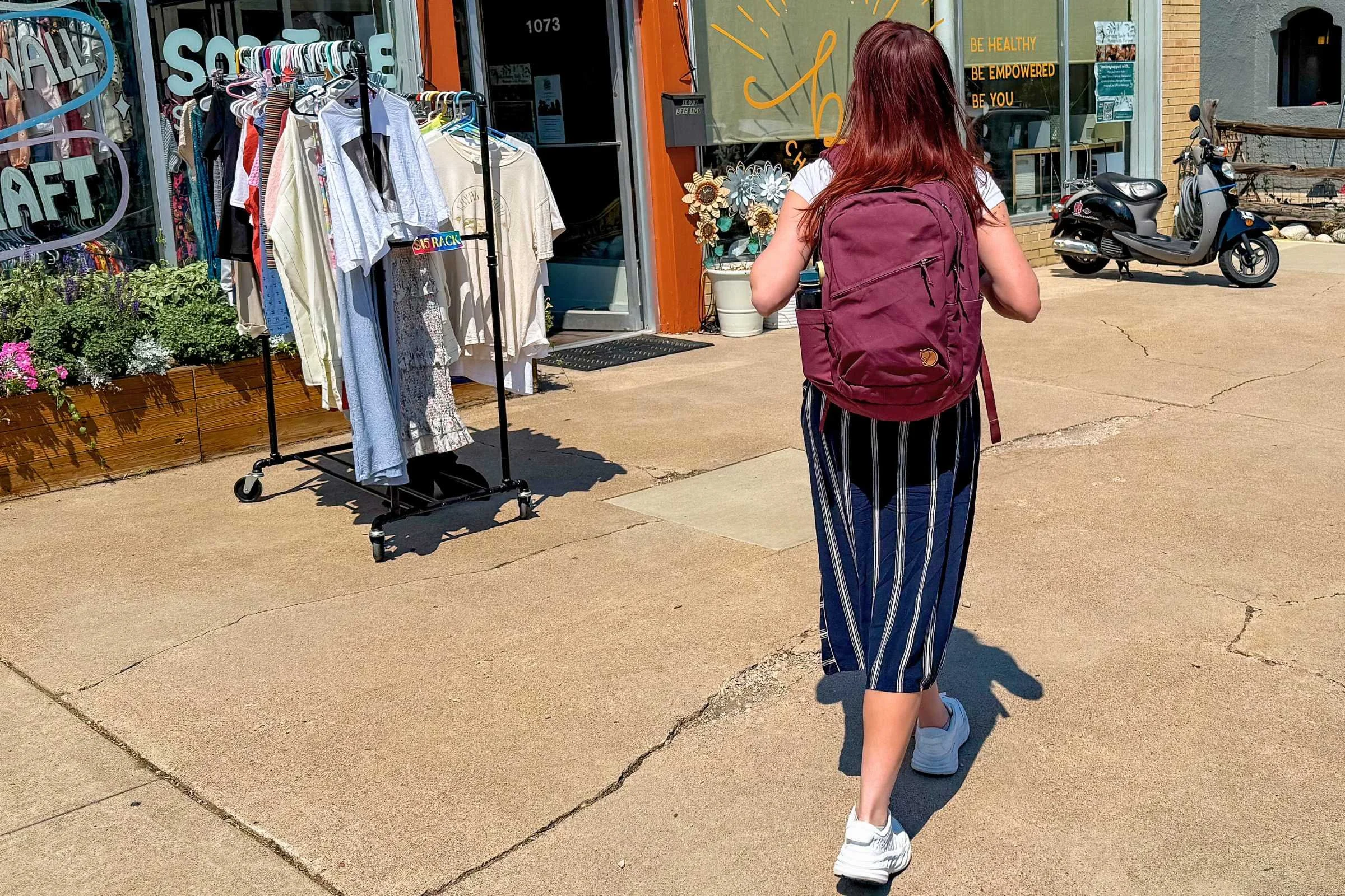 woman outside a clothing store wearing white hoka bondi sr shoes