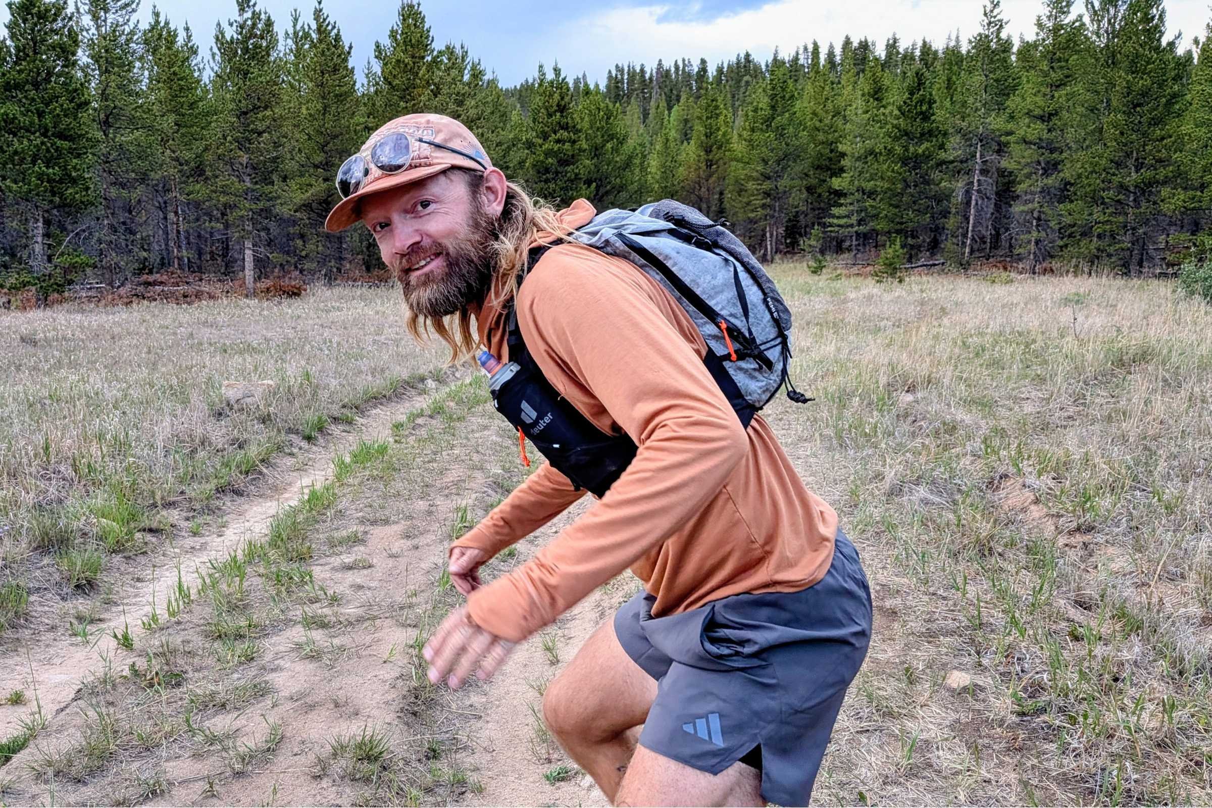 Hyperlite Mountain Gear Pemi 15 Running Vest worn by a trail runner on a forested singletrack path