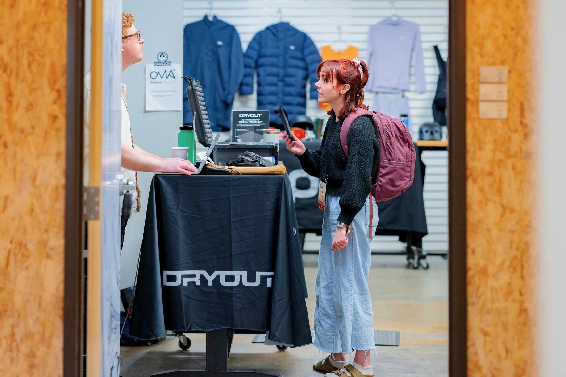 Treeline reviewer Becca speaking with a brand representative at the Outdoor Market Alliance show.