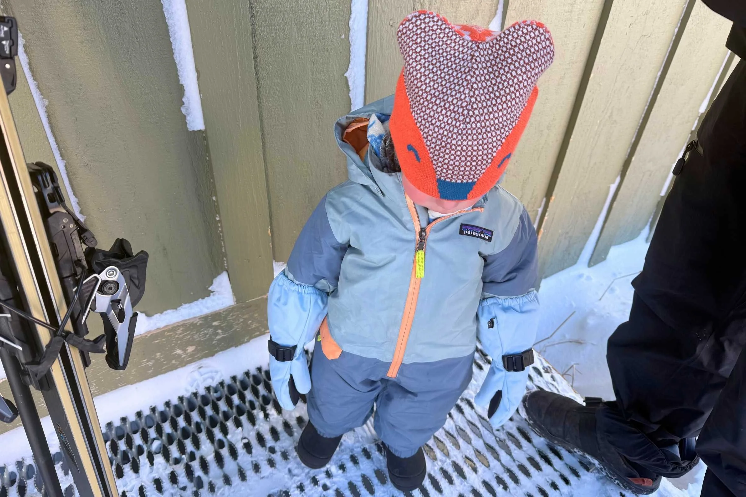 Child in full stone suit wearing insulated kids winter boots