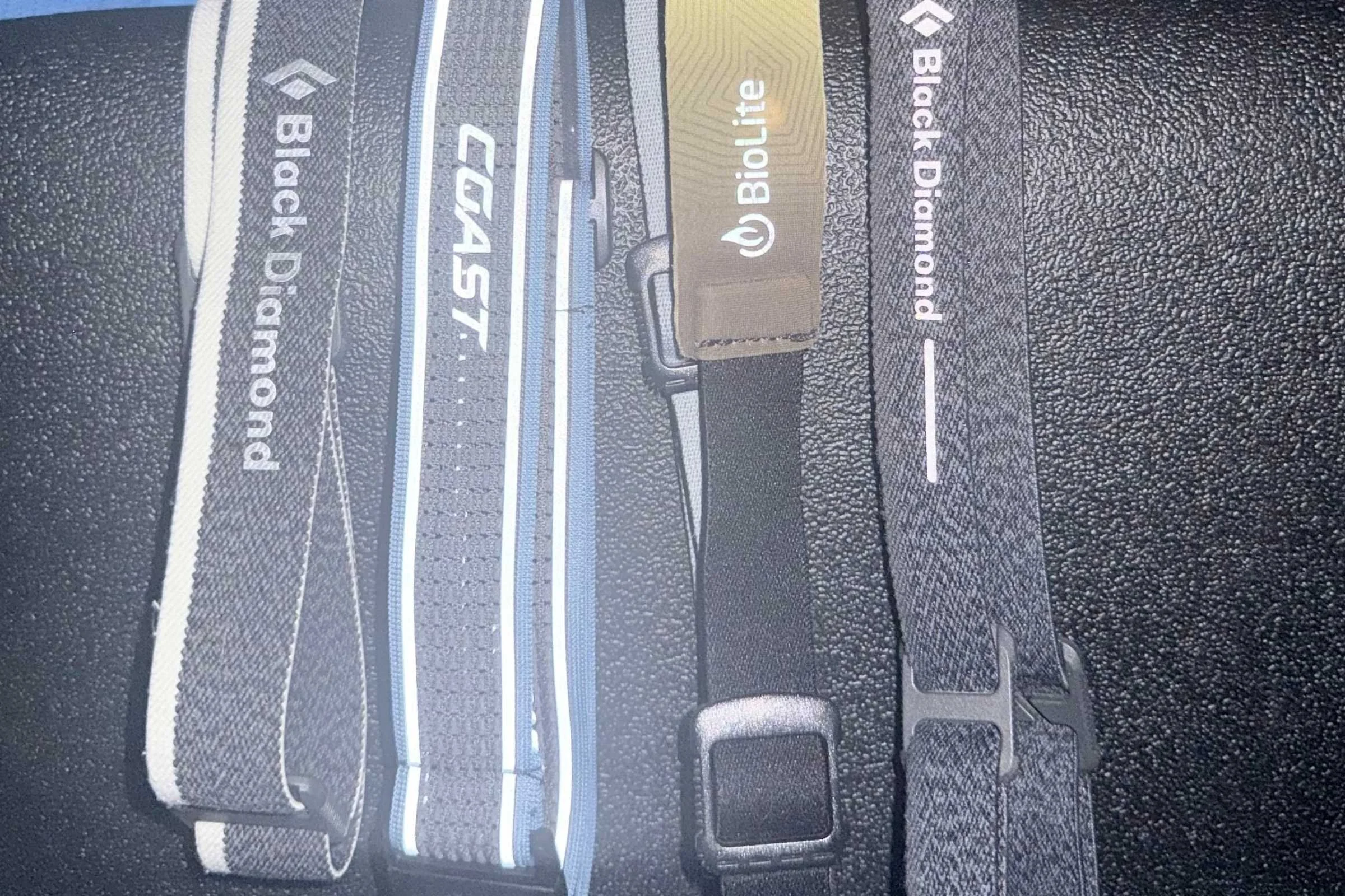 Comparing the bright reflective touchpoints around the whole band of the COAST strap, next to the Black Diamond Spot, BD Revolt, and Biolite Range.