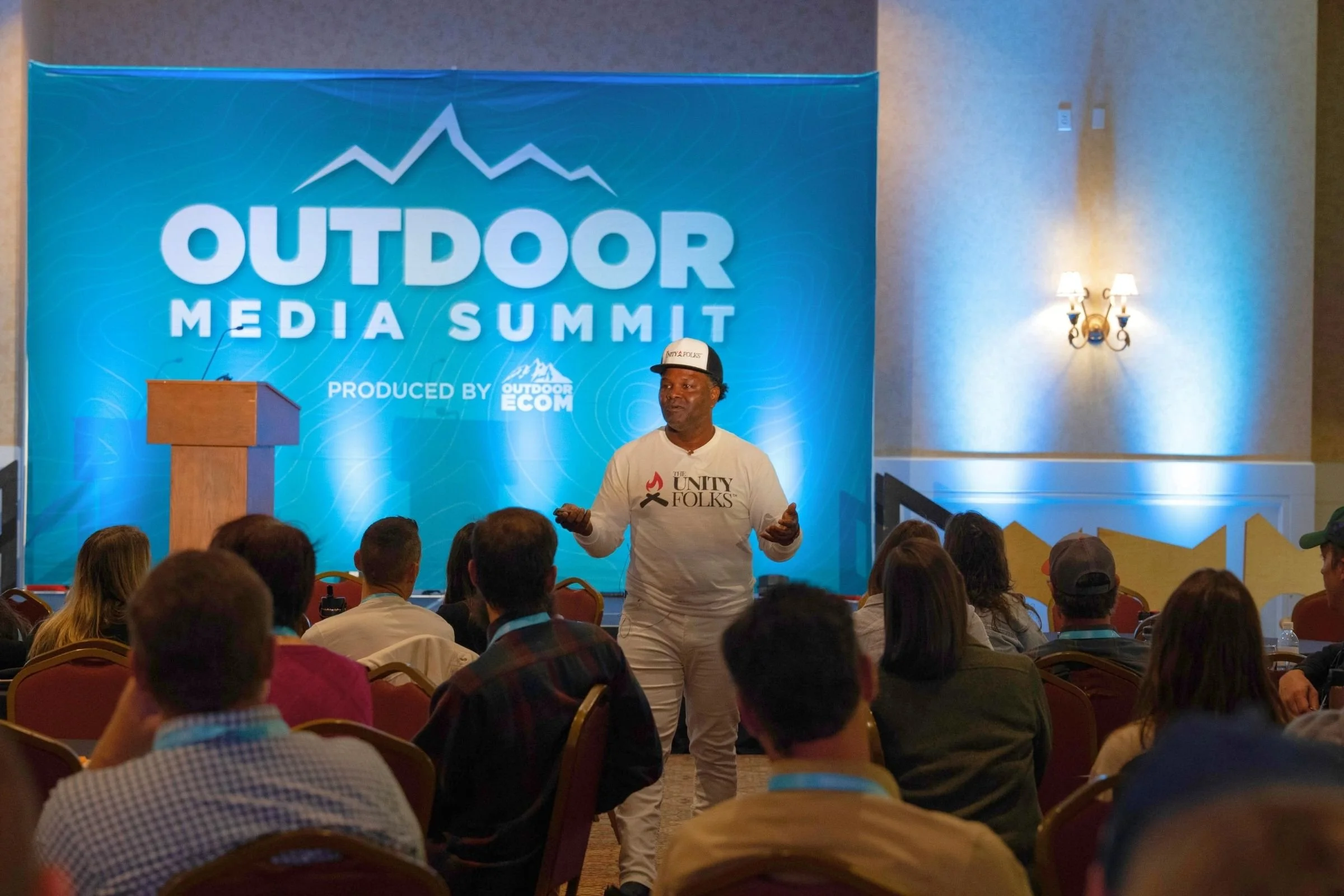 Man speaking on stage of OMS.