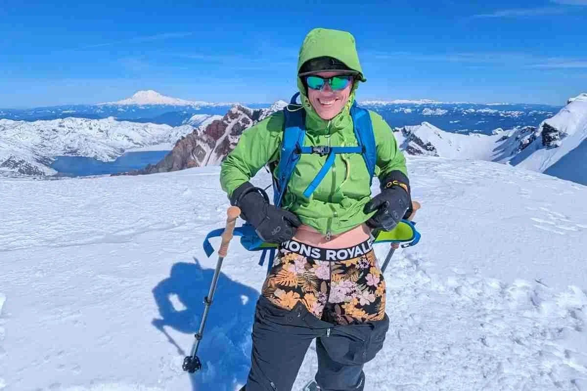 Skiier wearing long underwear on top of a snowy mountain