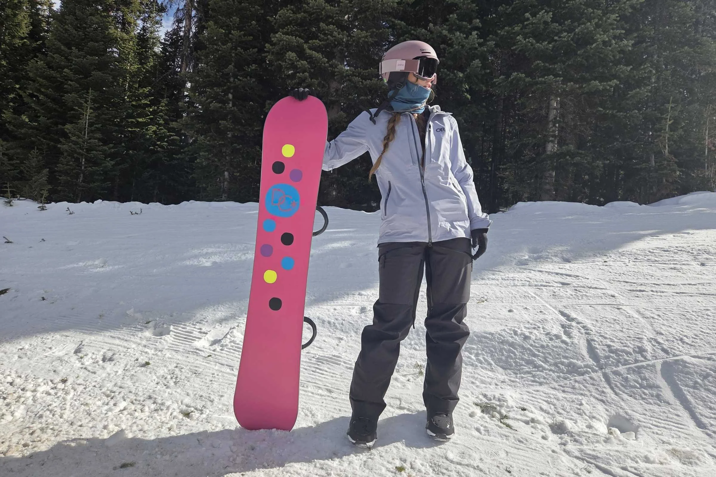 Snowboarder holding board wearing Outdoor Research ski jacket