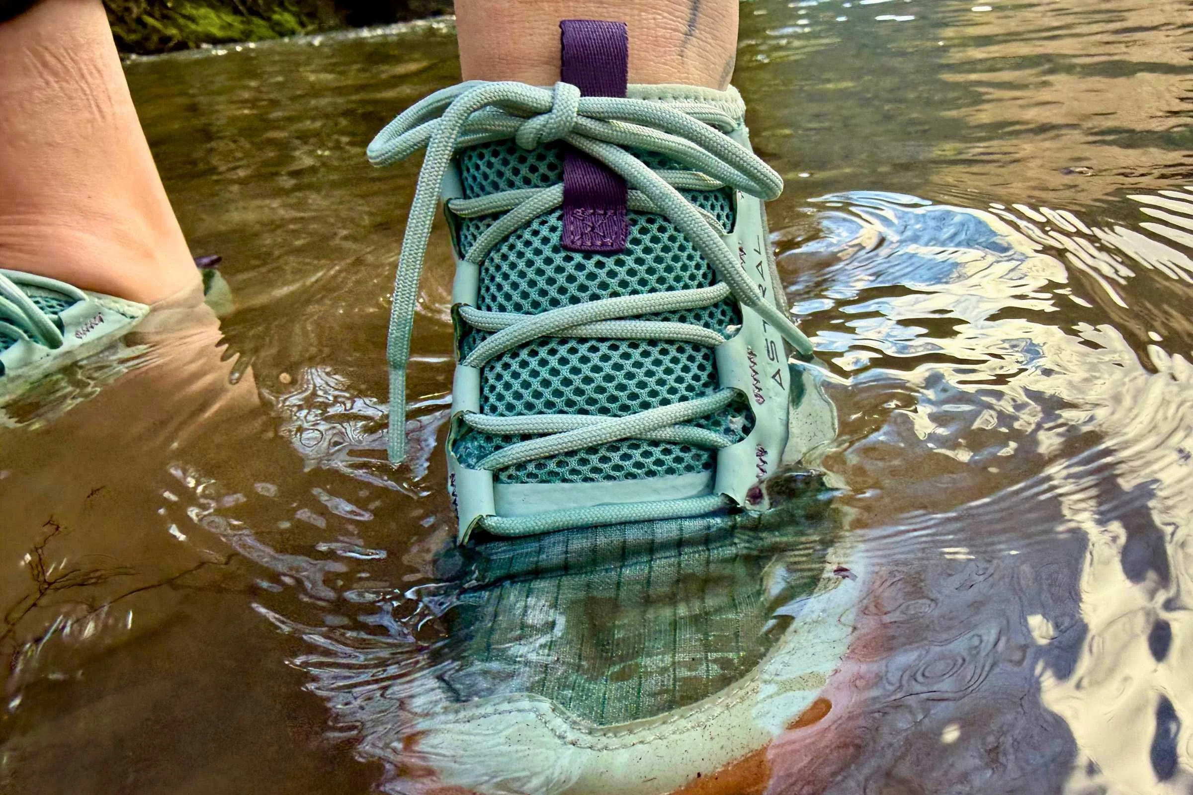 Teal Astral Loyak AC water shoes submerged in a river.