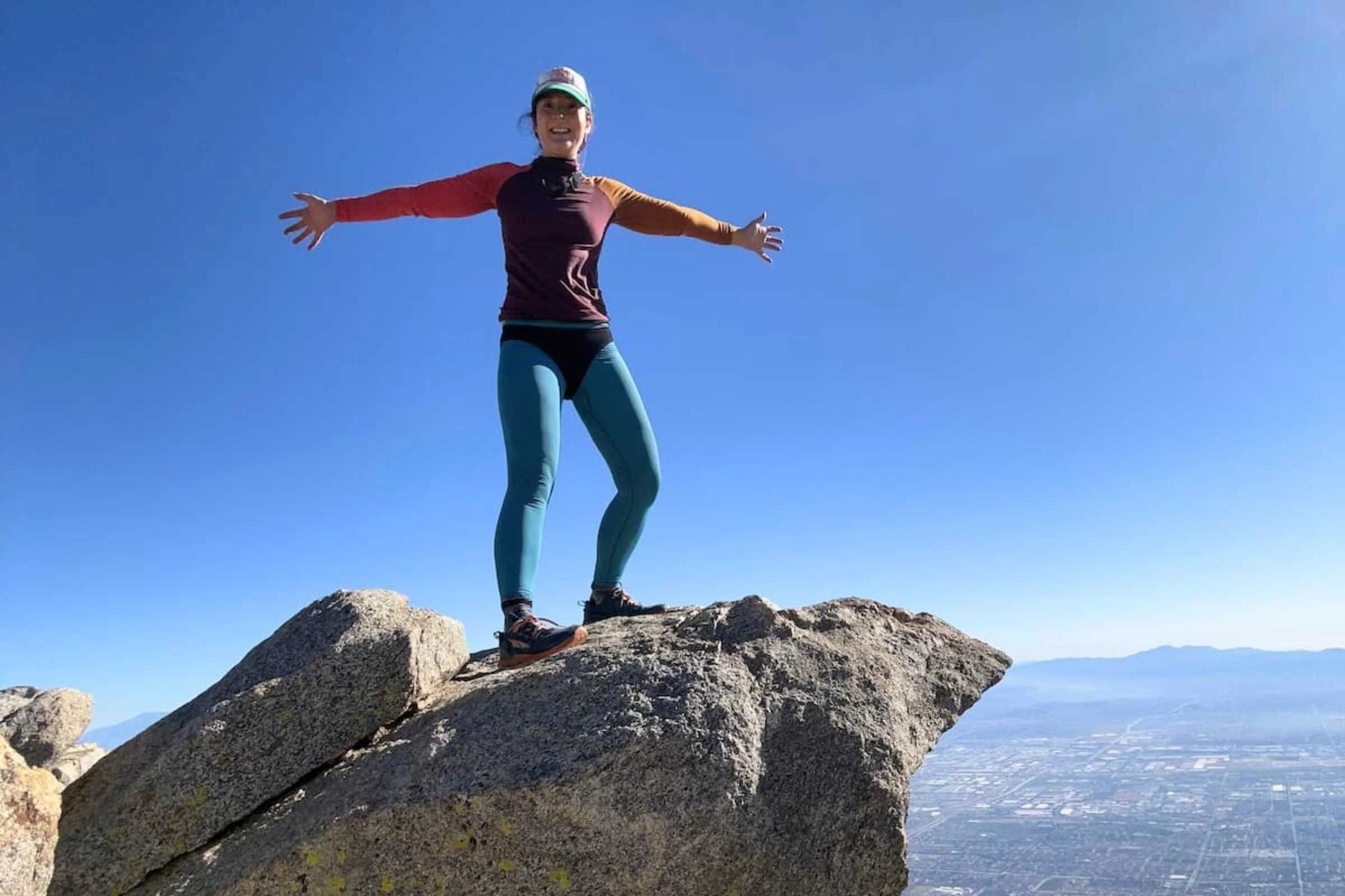 Hiker modeling the Branwyn Essential Merino Underwear over the top of blue leggings