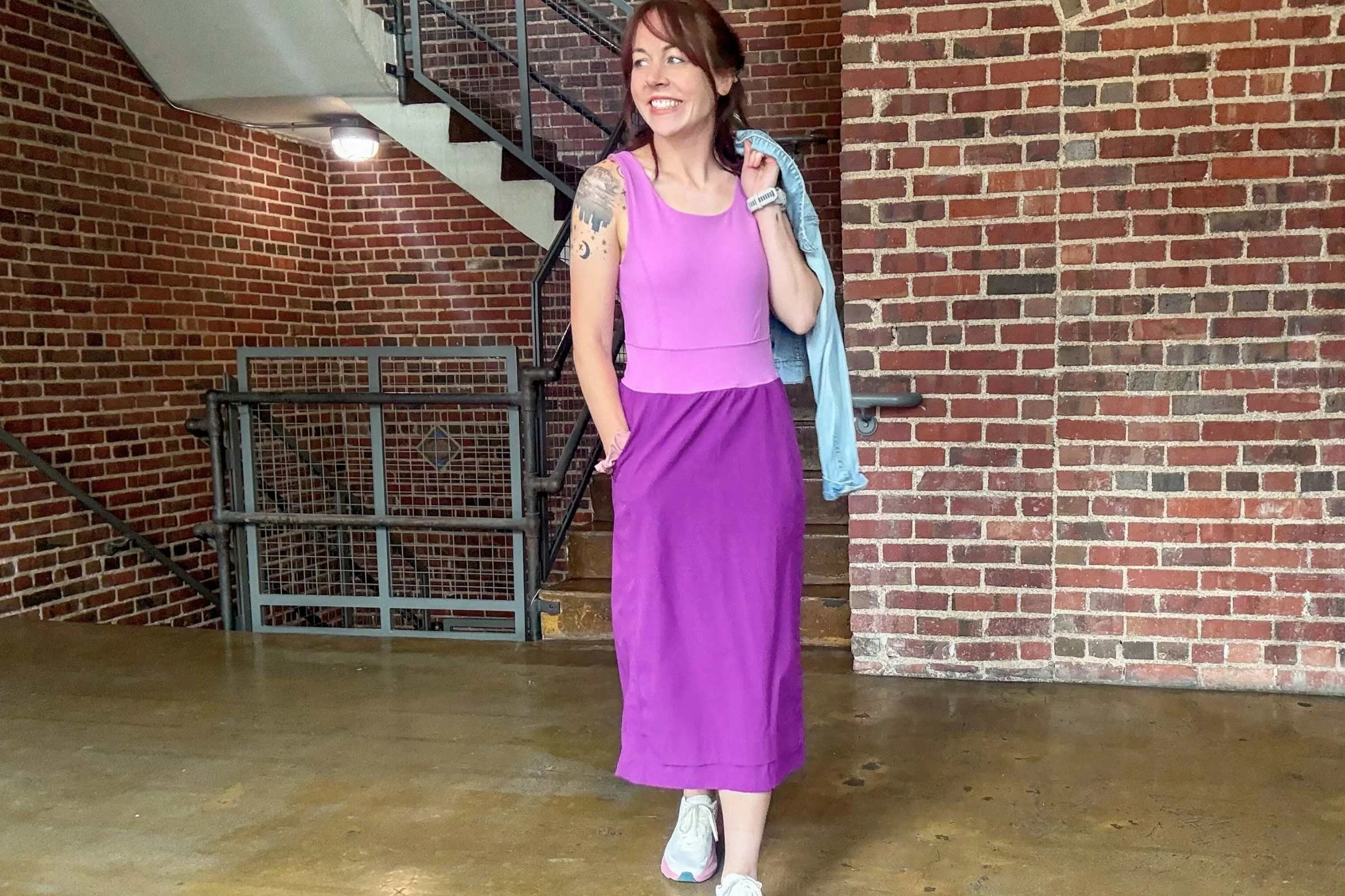 Wearing the Title Nine Limitless Midi Dress indoors with brick walls and stairs in the background