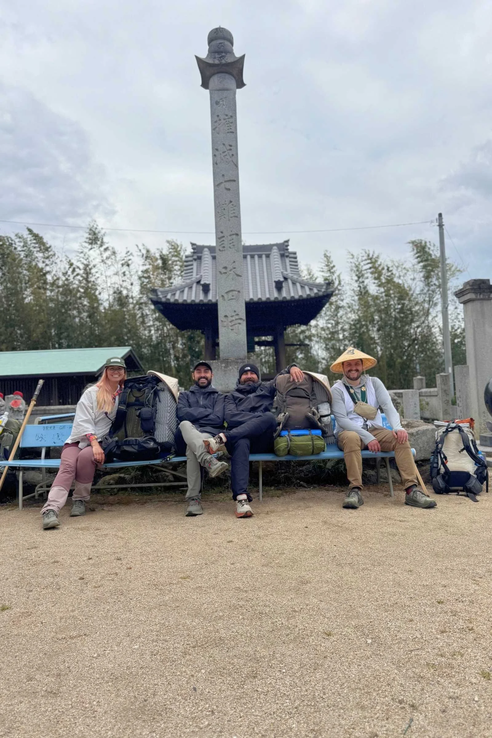 4 Pilgrims resting on a bench at a temple