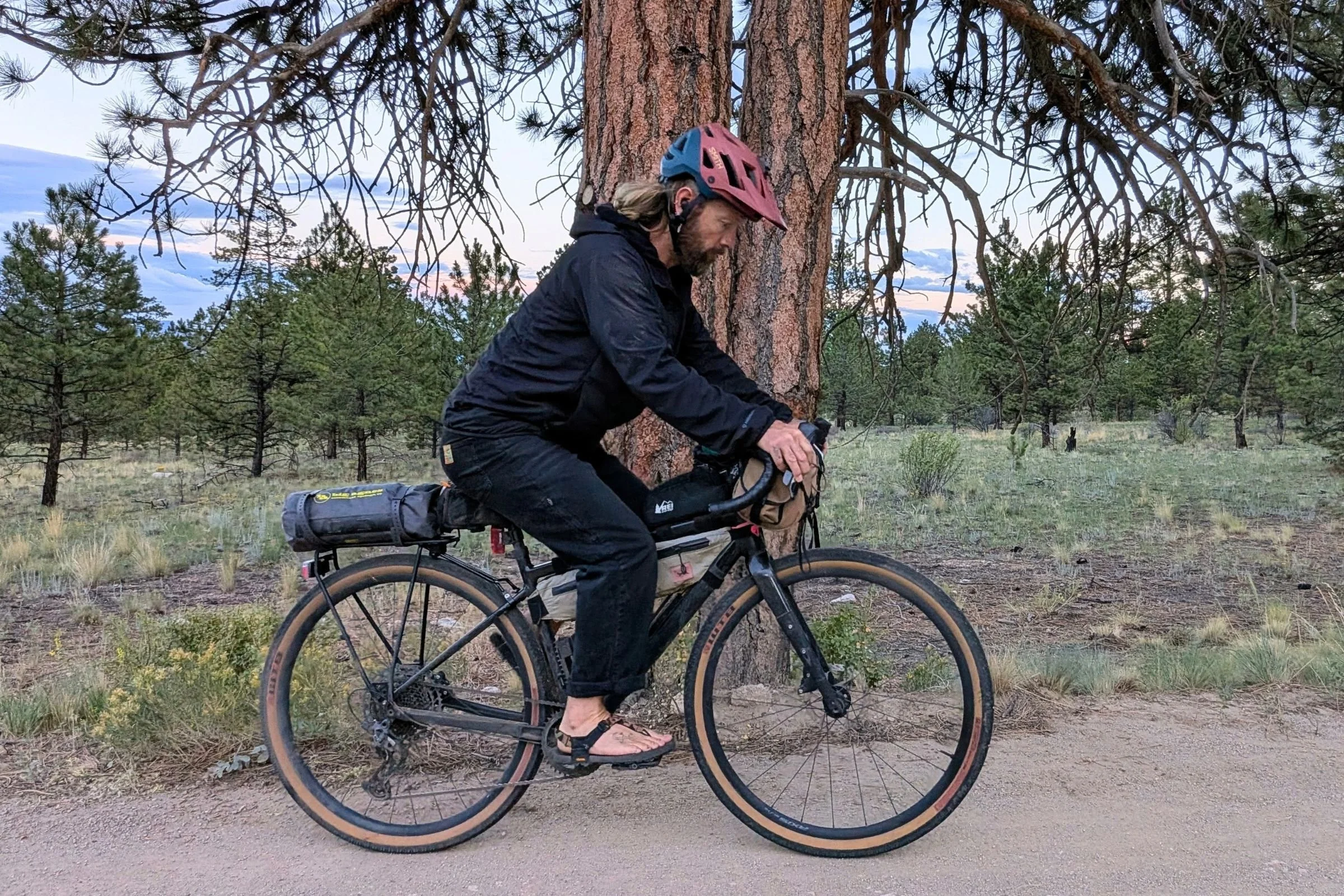 The author riding his bikepacking bike with the Big Agnes Tiger Wall UL1 Bikepack Tent strapped to the rear rack of his bike.