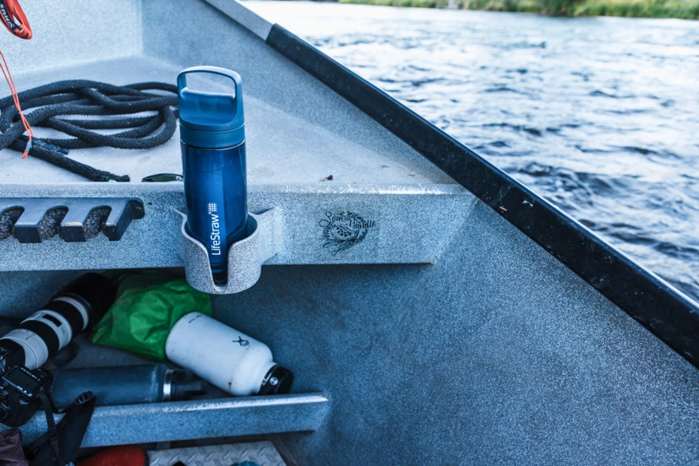 LifeStraw Go Series Travel Water Bottle in blue positioned on the side of a boat.