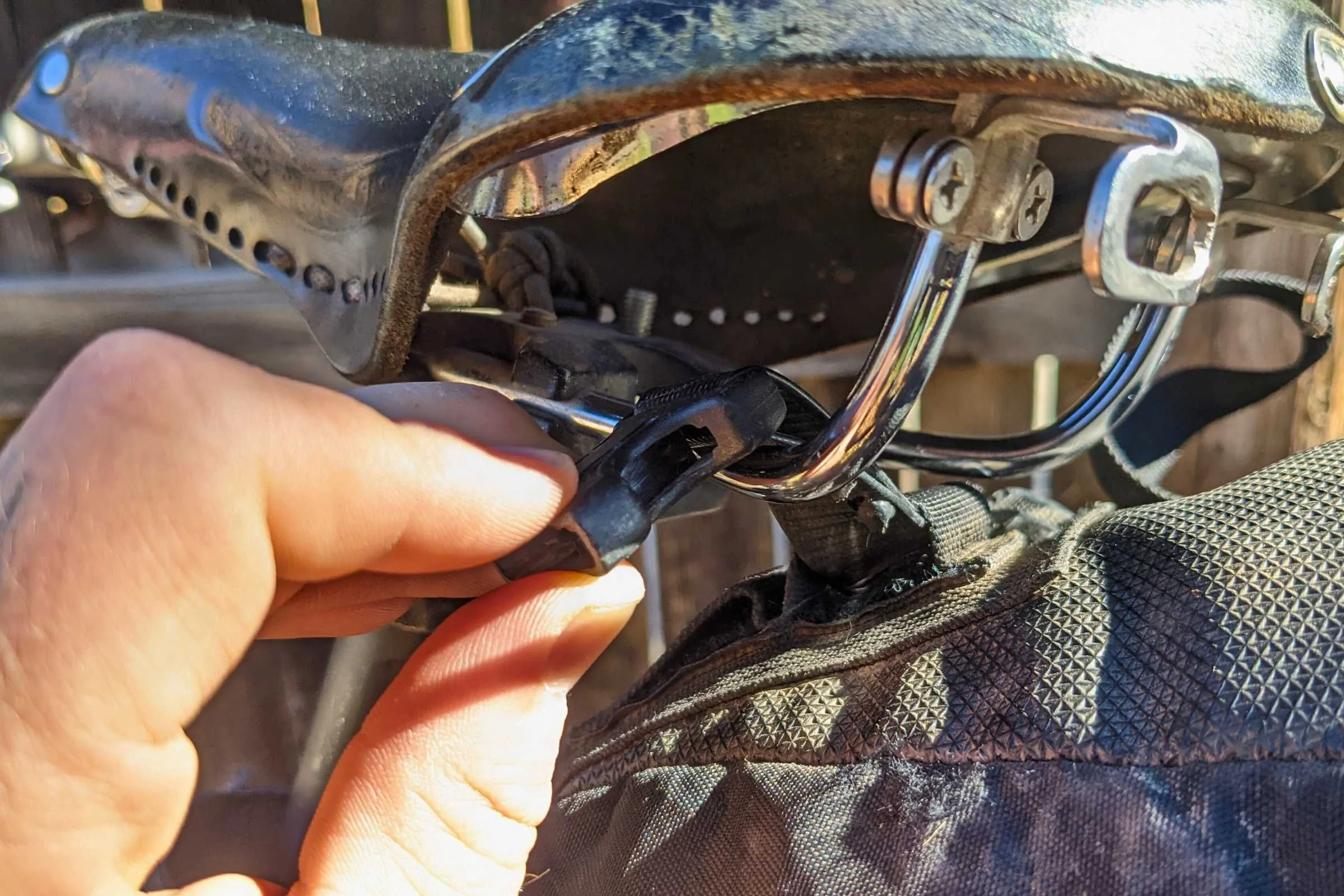 To set up a saddle bag, loop straps through rails and clip them onto the bag.