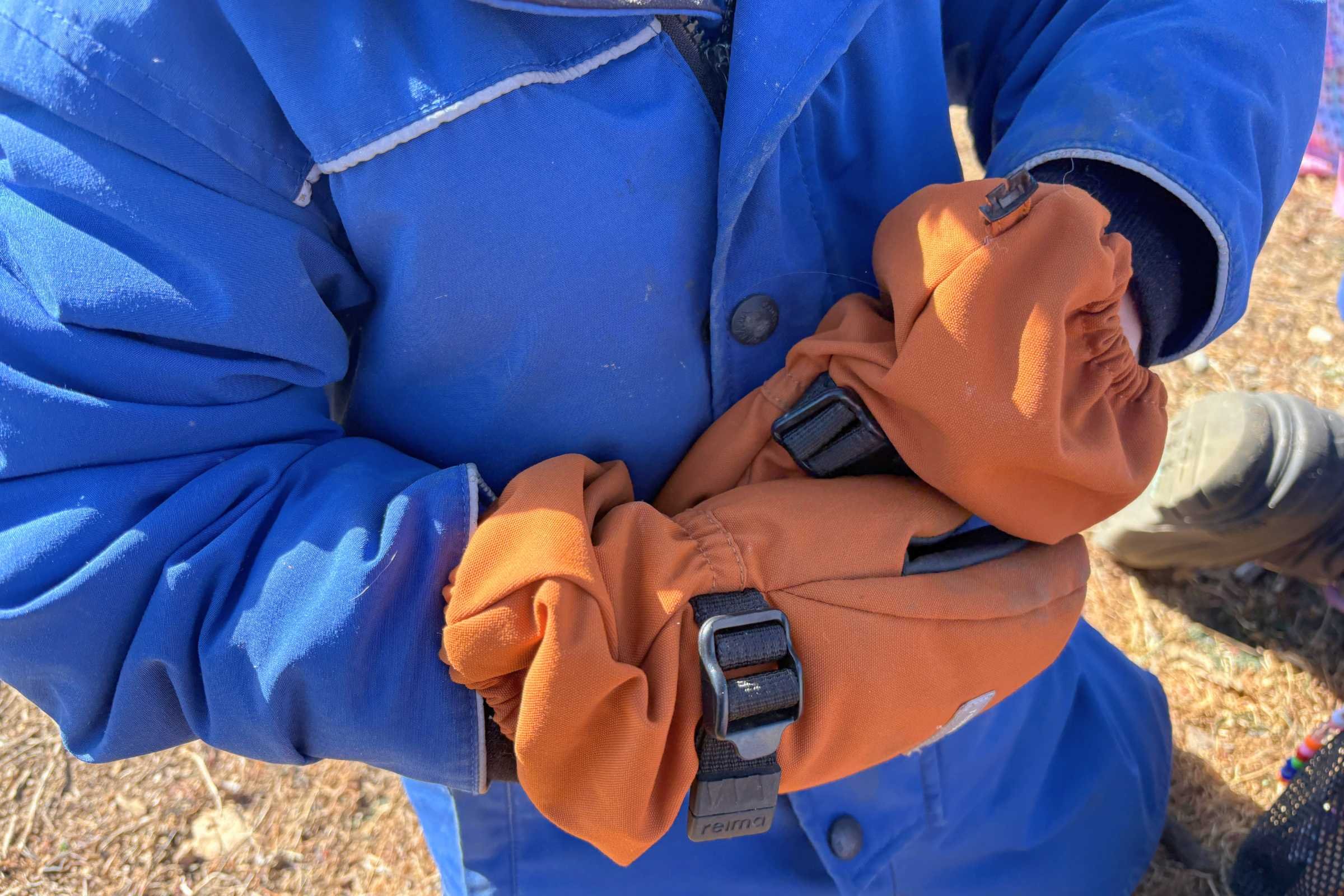 Child showing how they can remove the Reima Ote mittens themselves