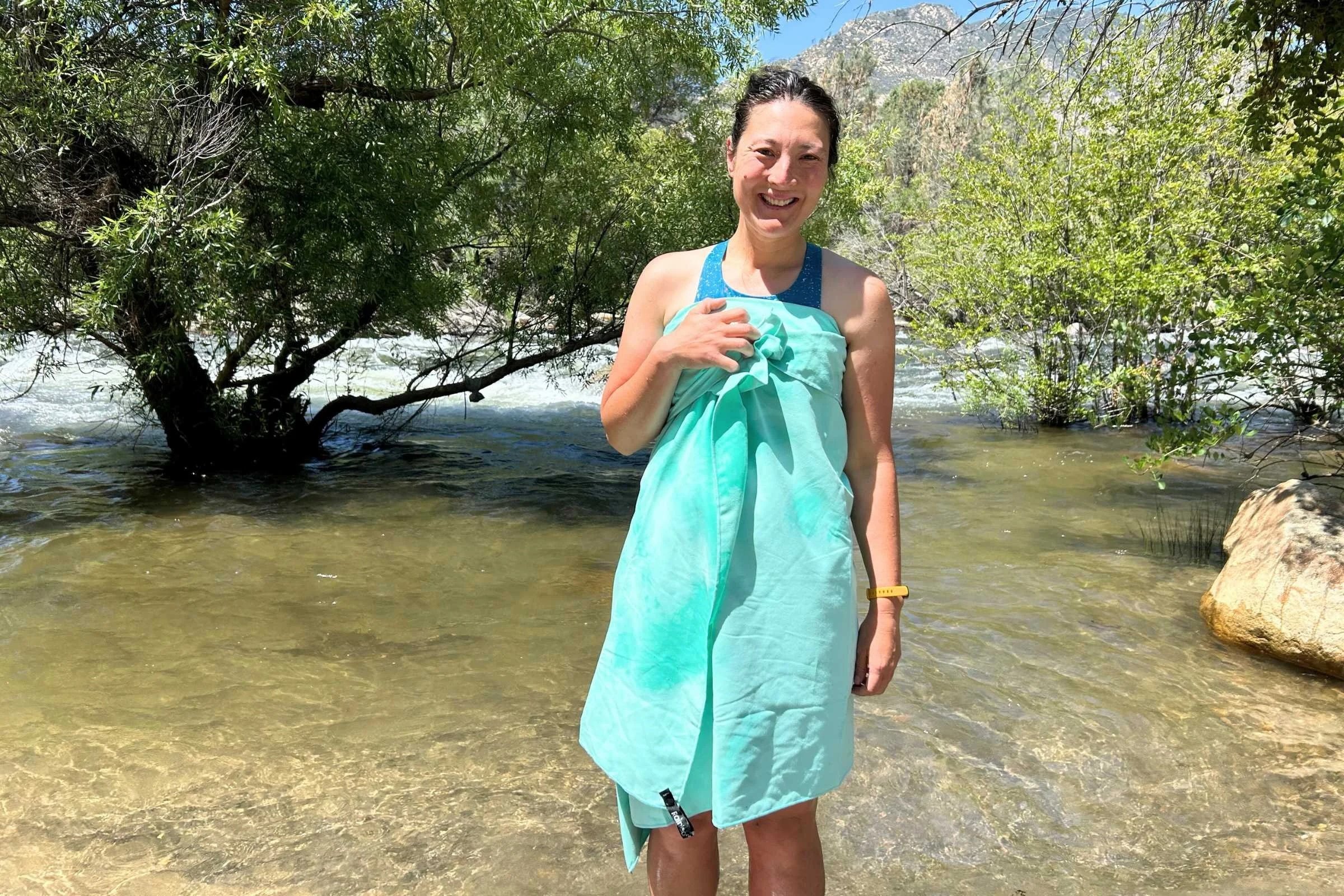 Person wearing a quick dry camping towel standing in a river