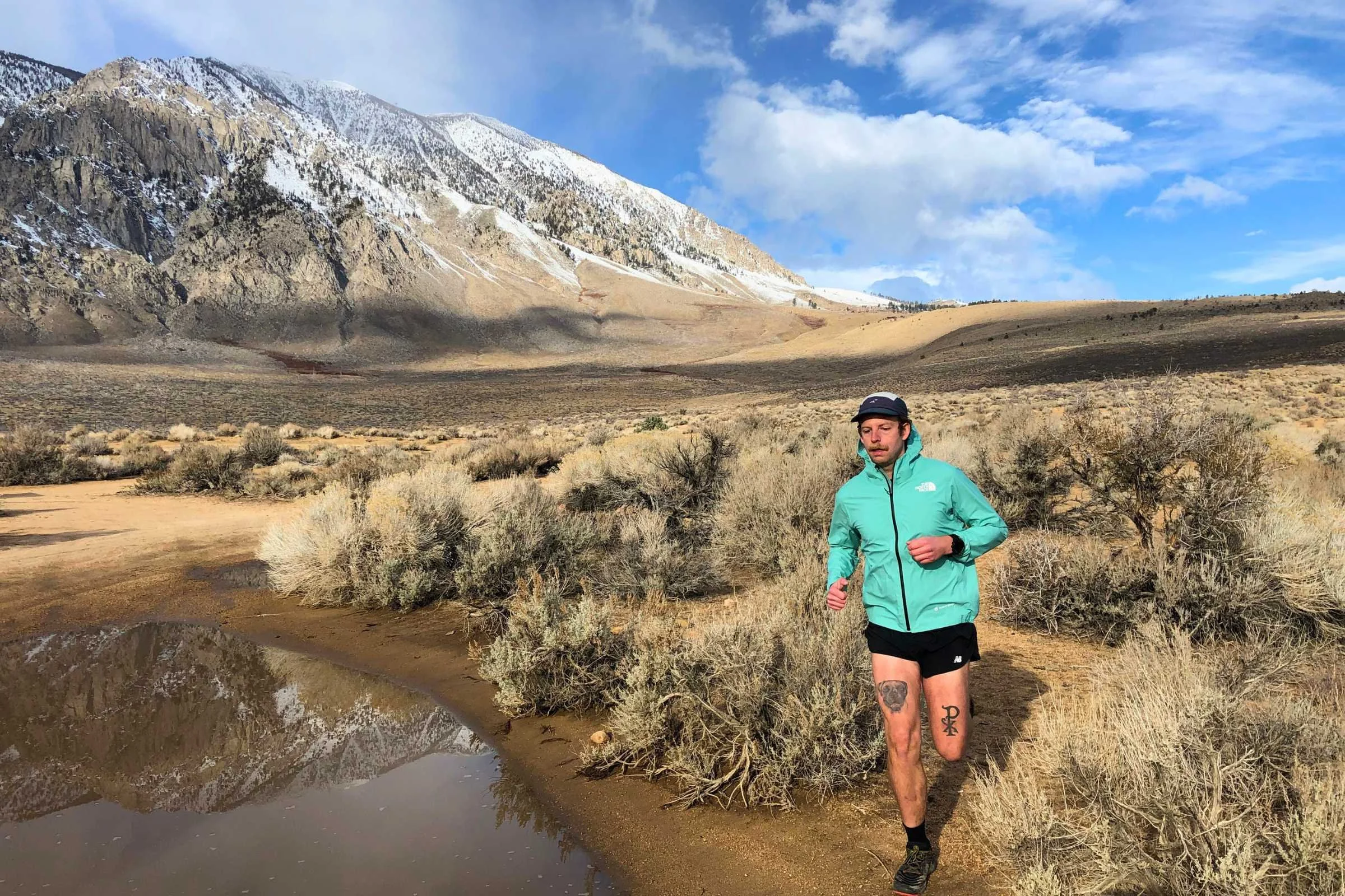 Man running by a puddle wearing a The North Face jacket