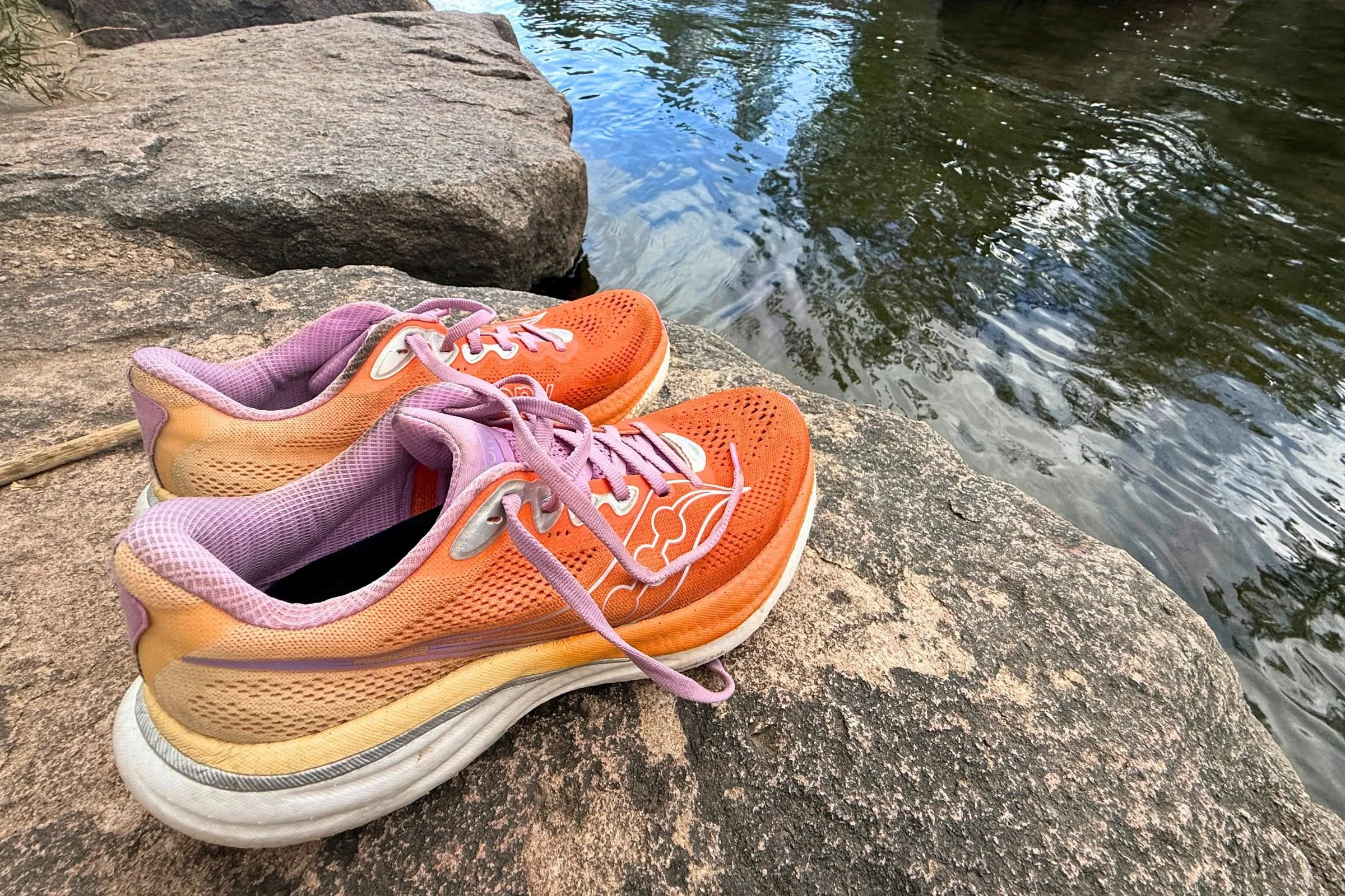 Saucony Ride 19 Road Running Shoes on a rock above a creek.