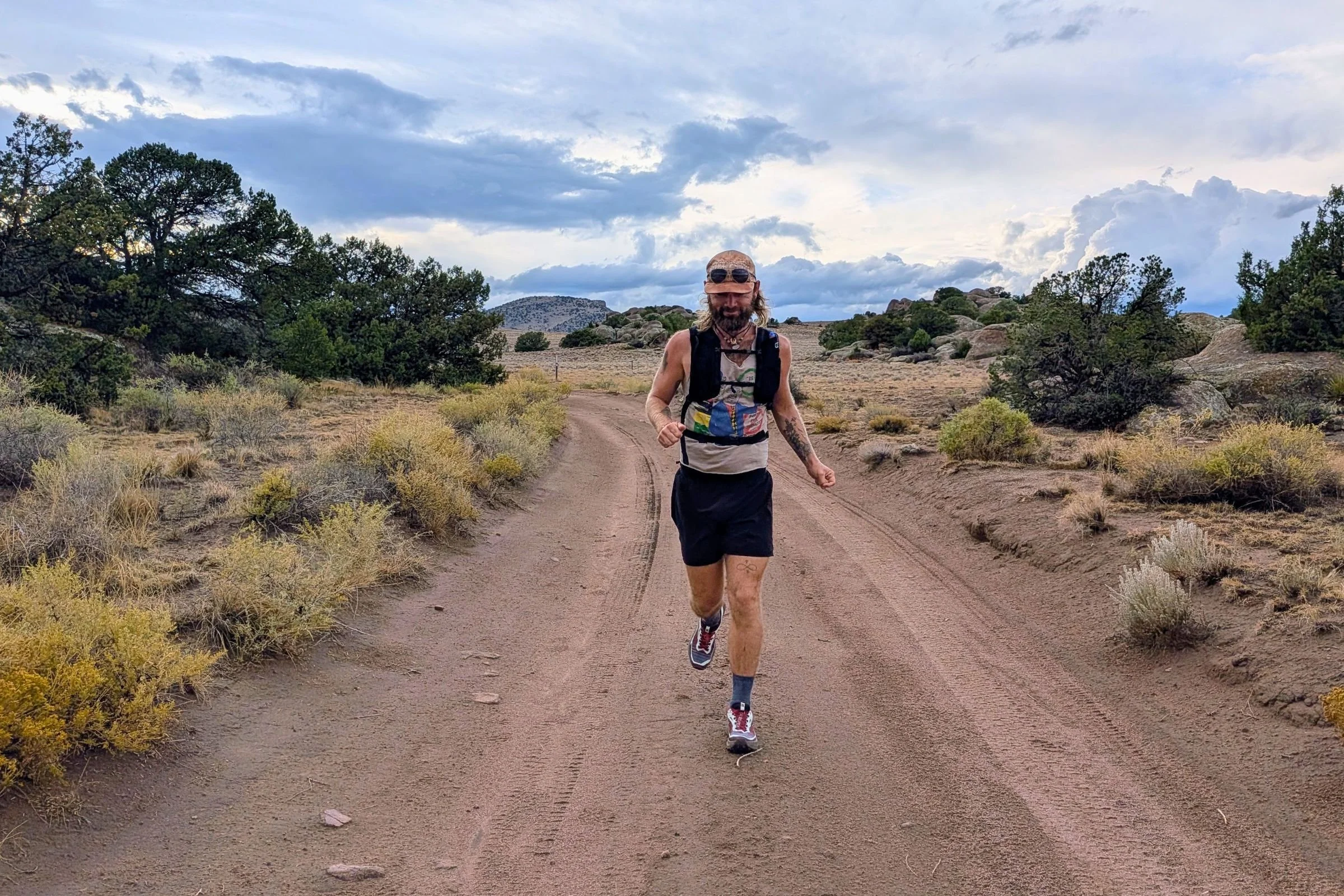 A man wearing Salomon Genesis 2 Trail Running Shoes runs along a desert dirt road.