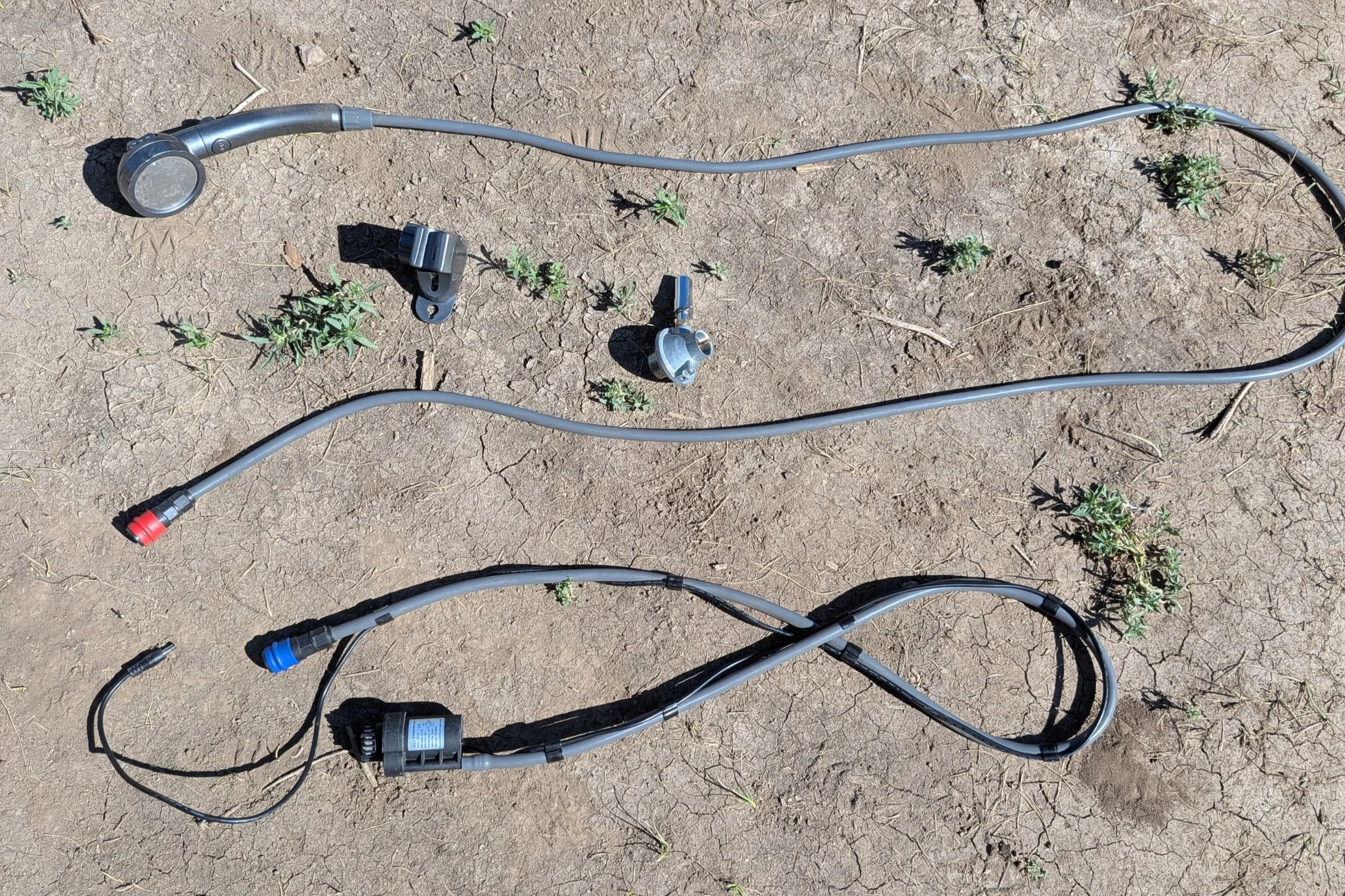 BougeRV Portable Propane Outdoor Water Heater with wires and a hose laid out on the ground.