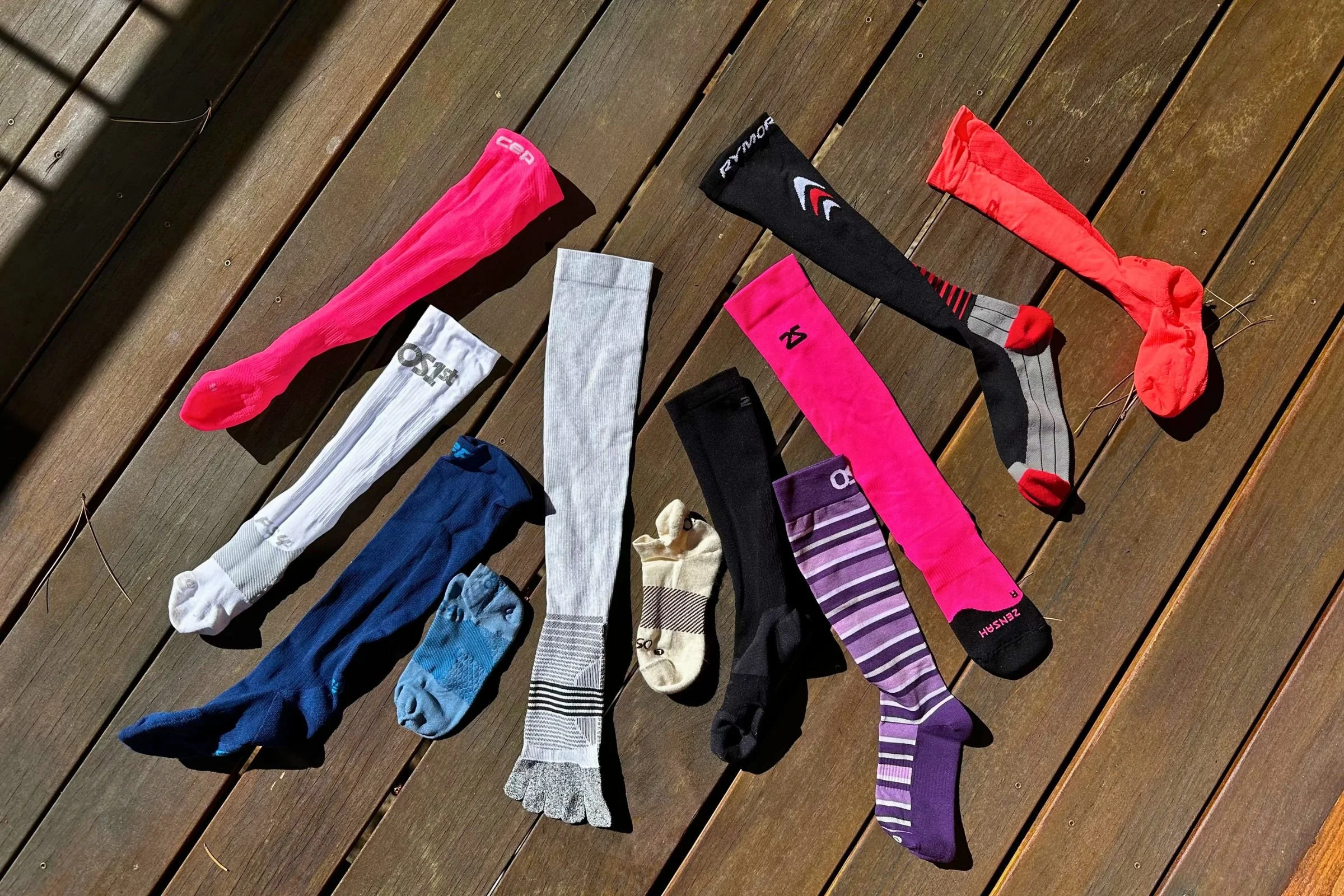 Types of running compression socks laid on on a wood deck