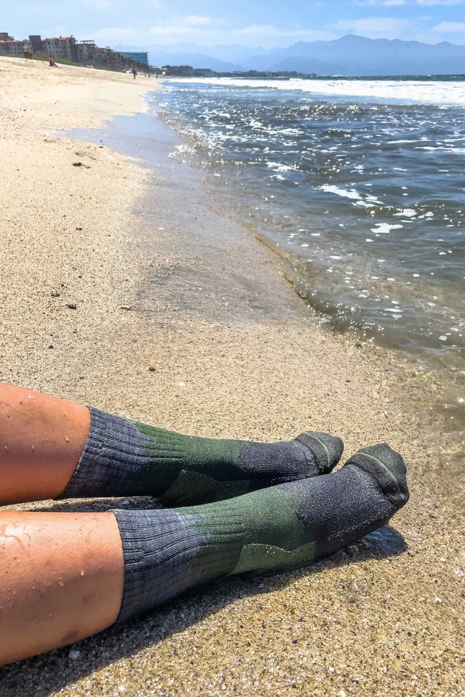 wearing wet Darn tough socks  in the sand on a beach