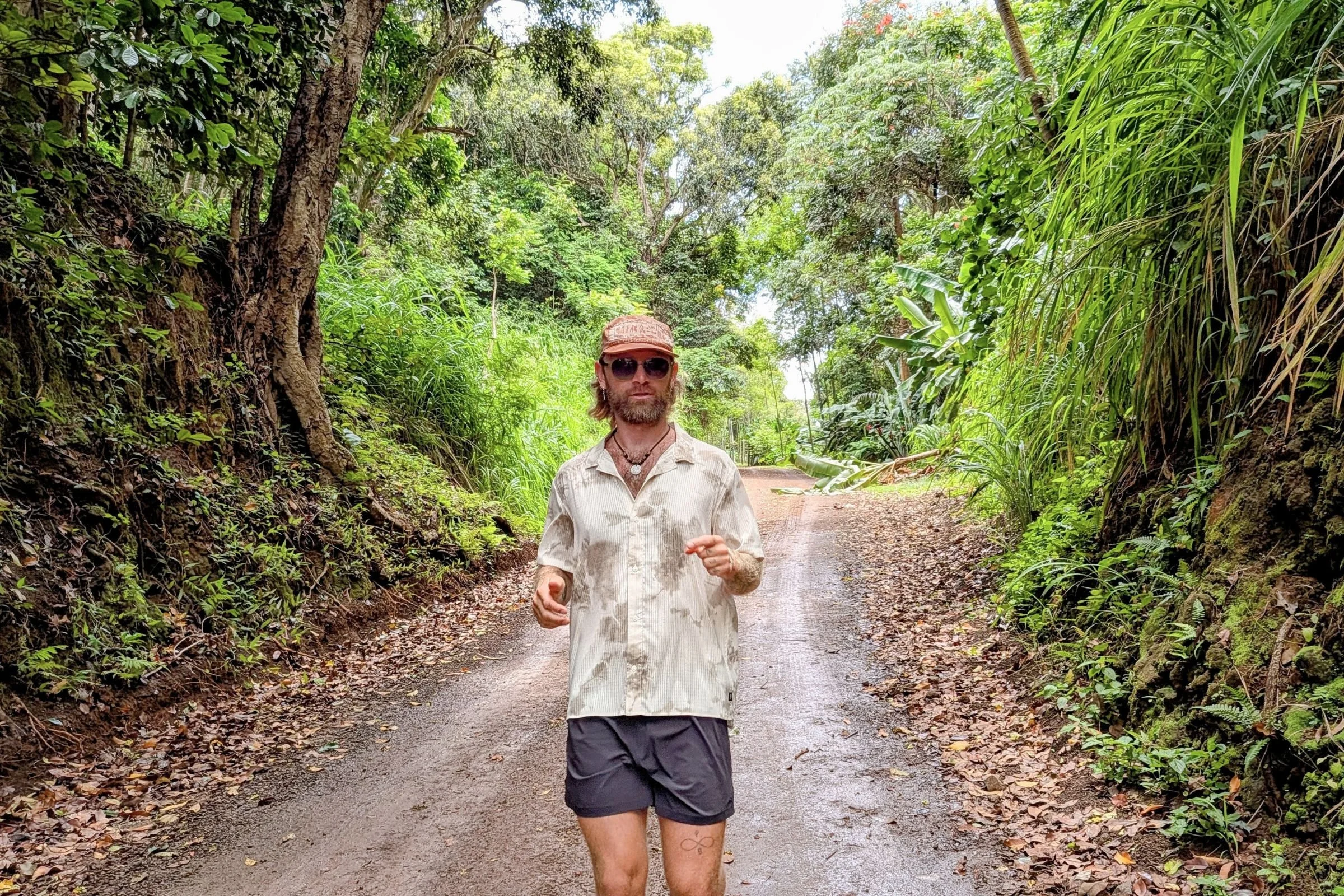 Tracksmith Twilight Running Shorts worn by a runner on a dirt road in the jungle.