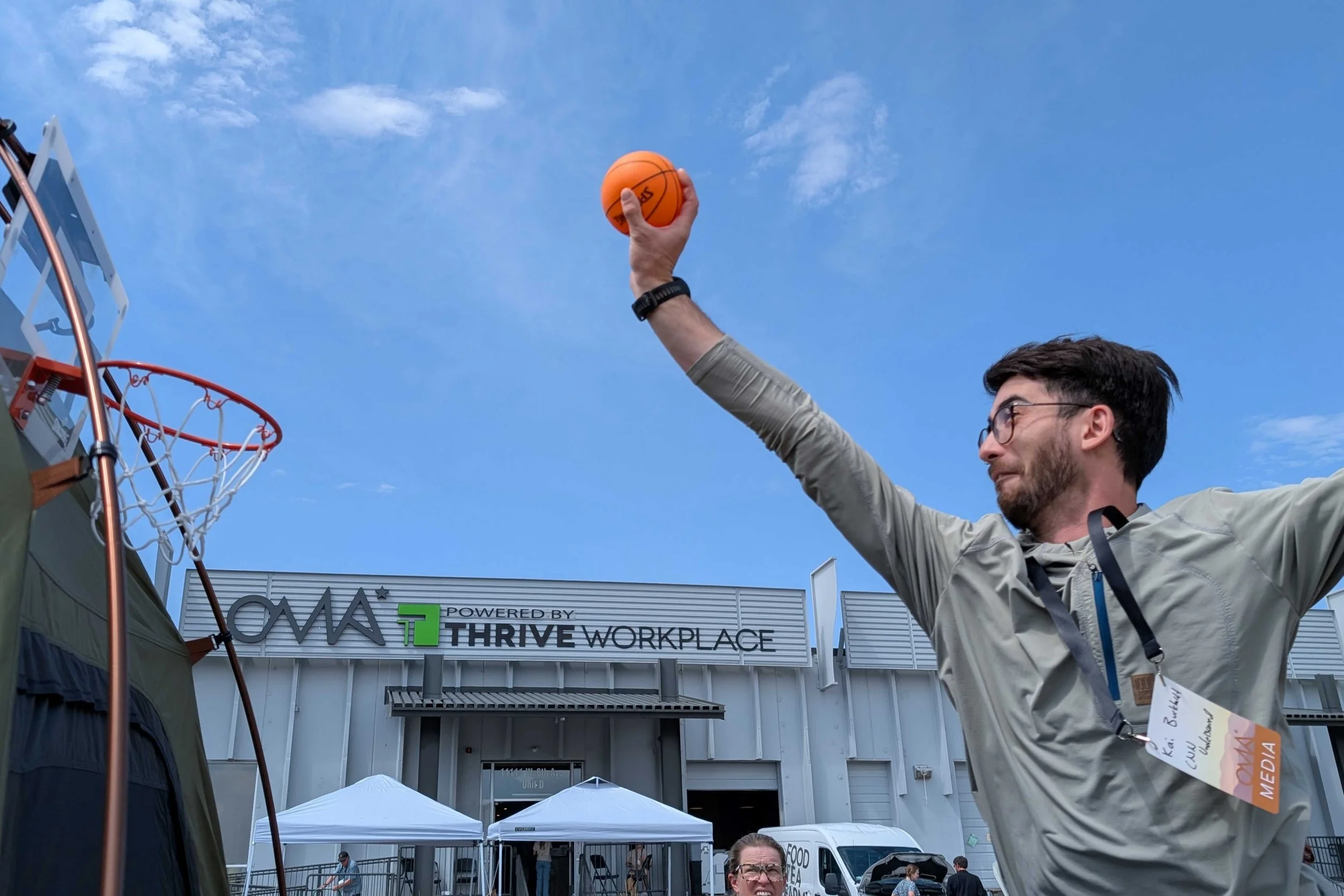 Kai goes for the slam dunk on the basketball hoop mounted on the Kelty Highroads tent outside Outdoor Market Alliance's headquarters.