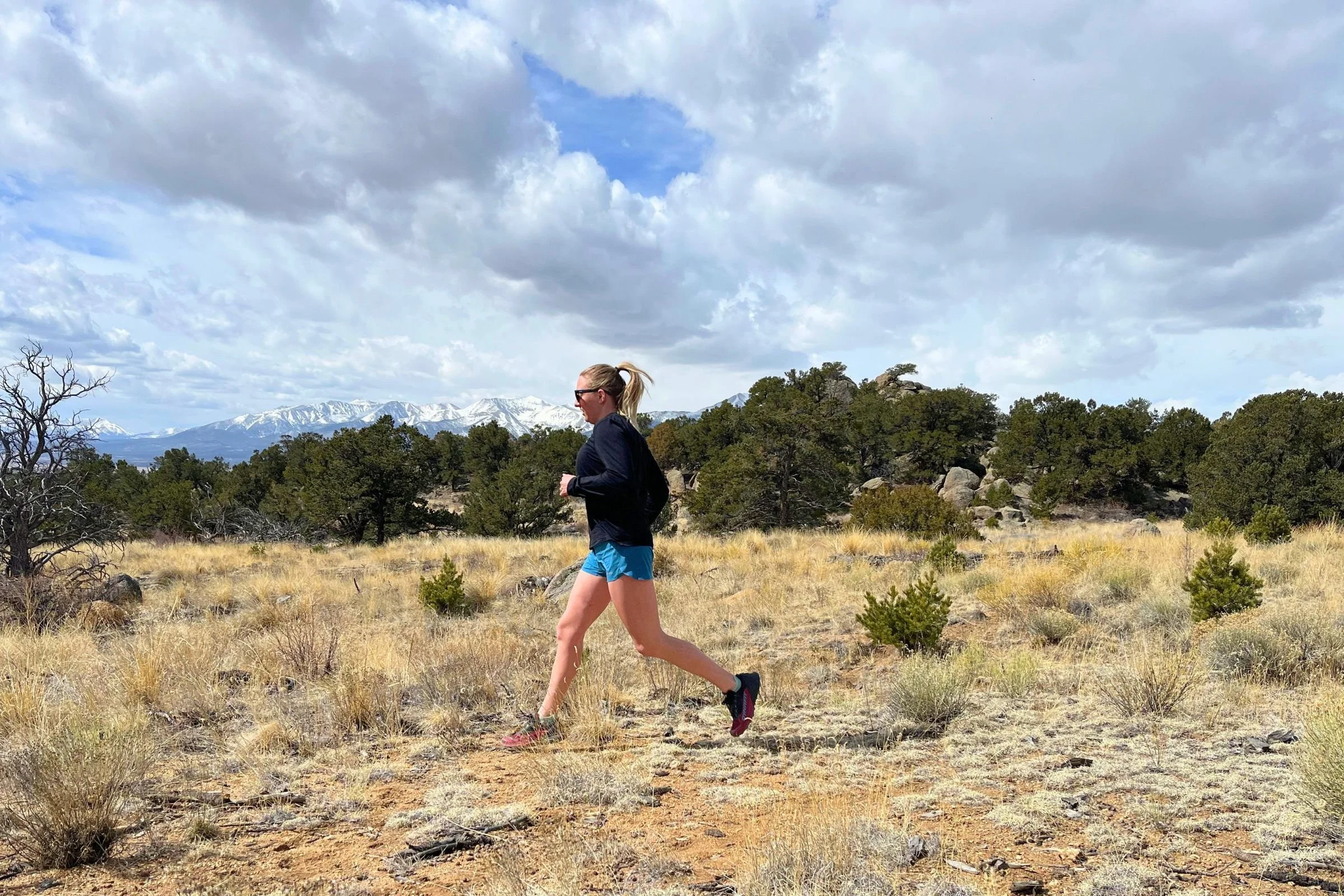 Woman running in the desert on a cloudy day, wearing Patagonia Strider Pro shorts.
