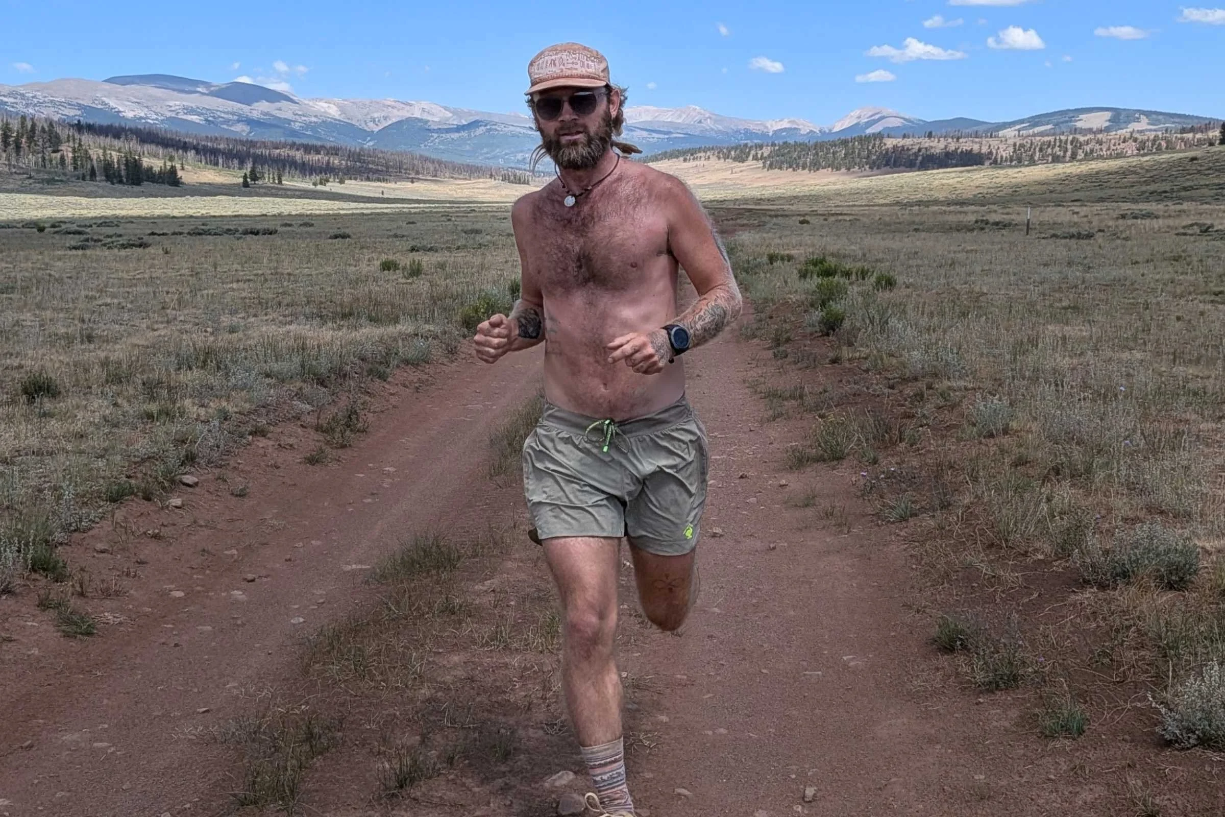 A runner in rabbit FKT shorts on a dirt road in Colorado