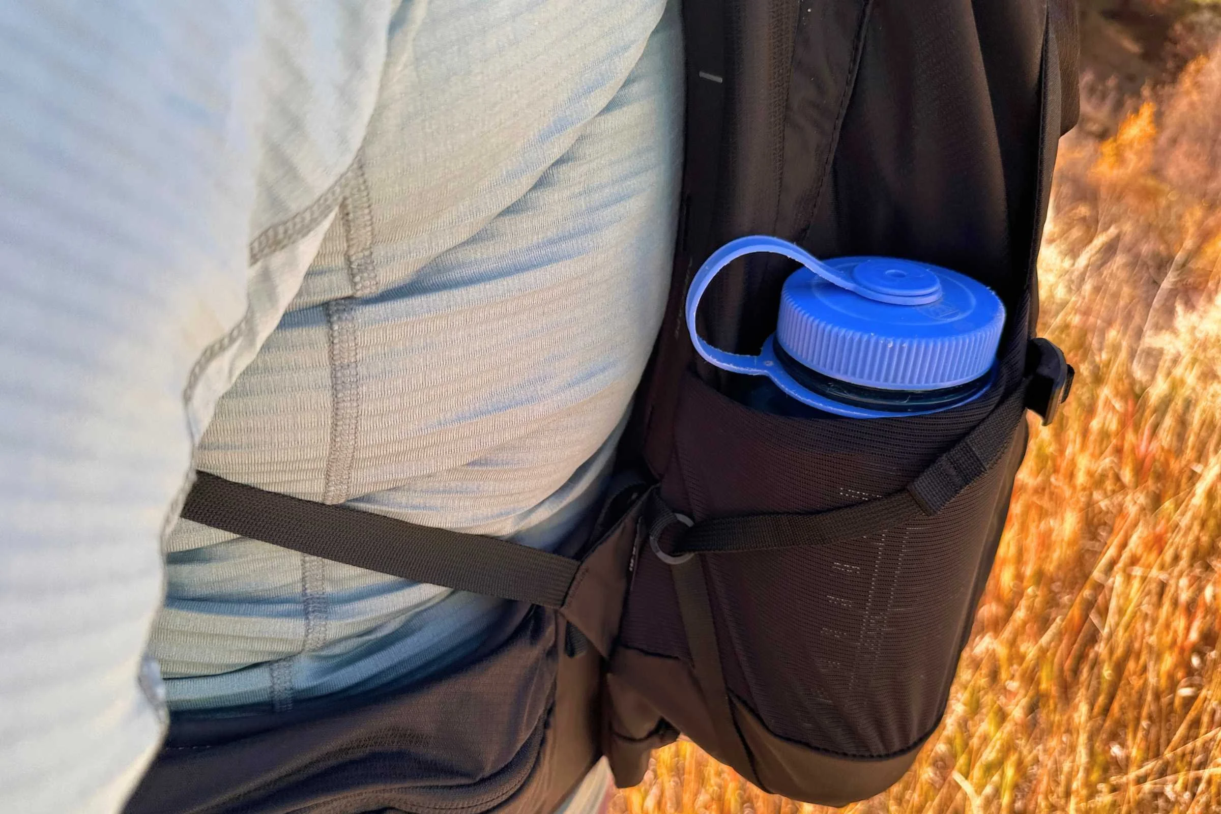 Osprey Tempest from the side displaying the bottle sleeve and side pockets.