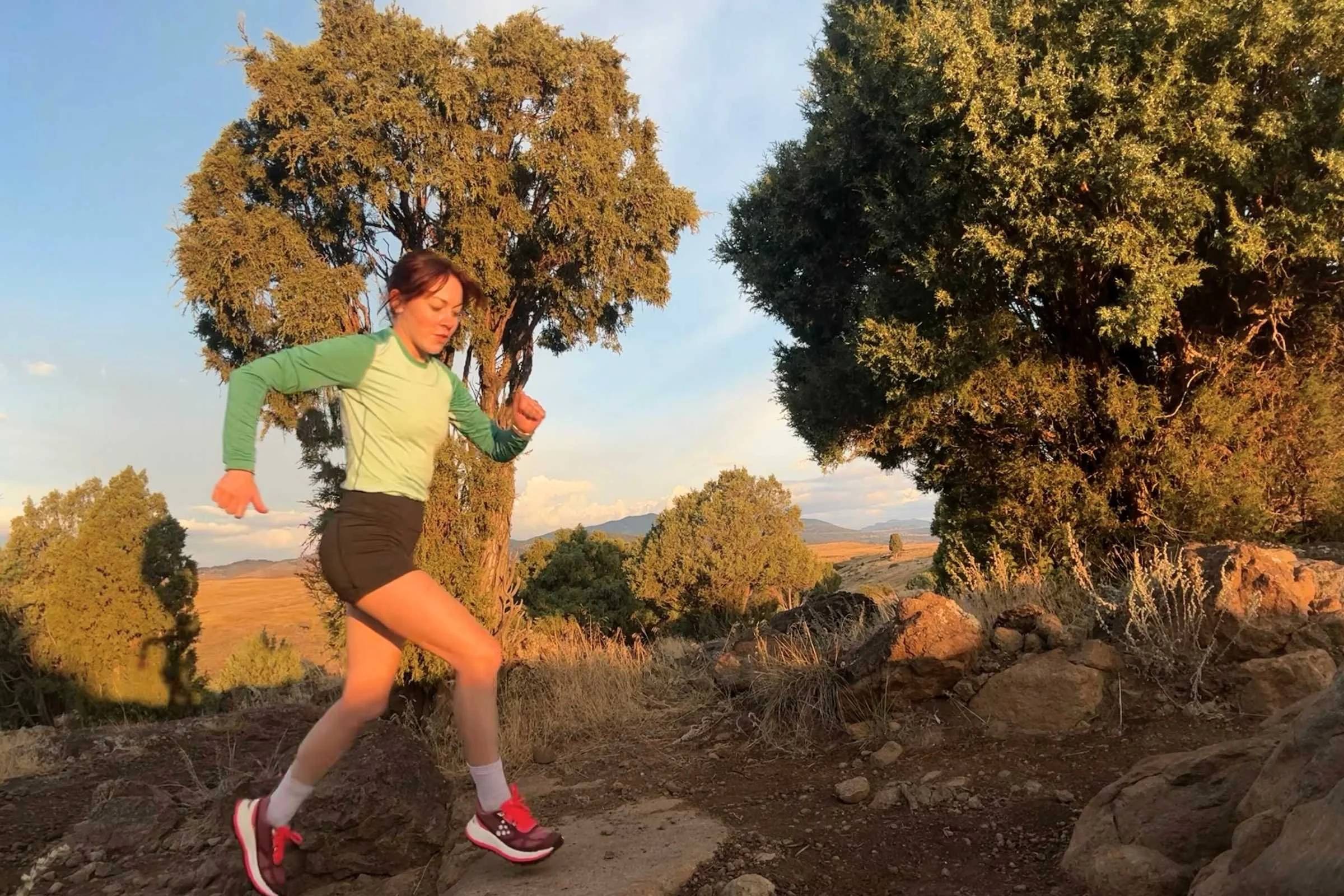 woman trail running at sunset in the craft xplor 2 running shoes