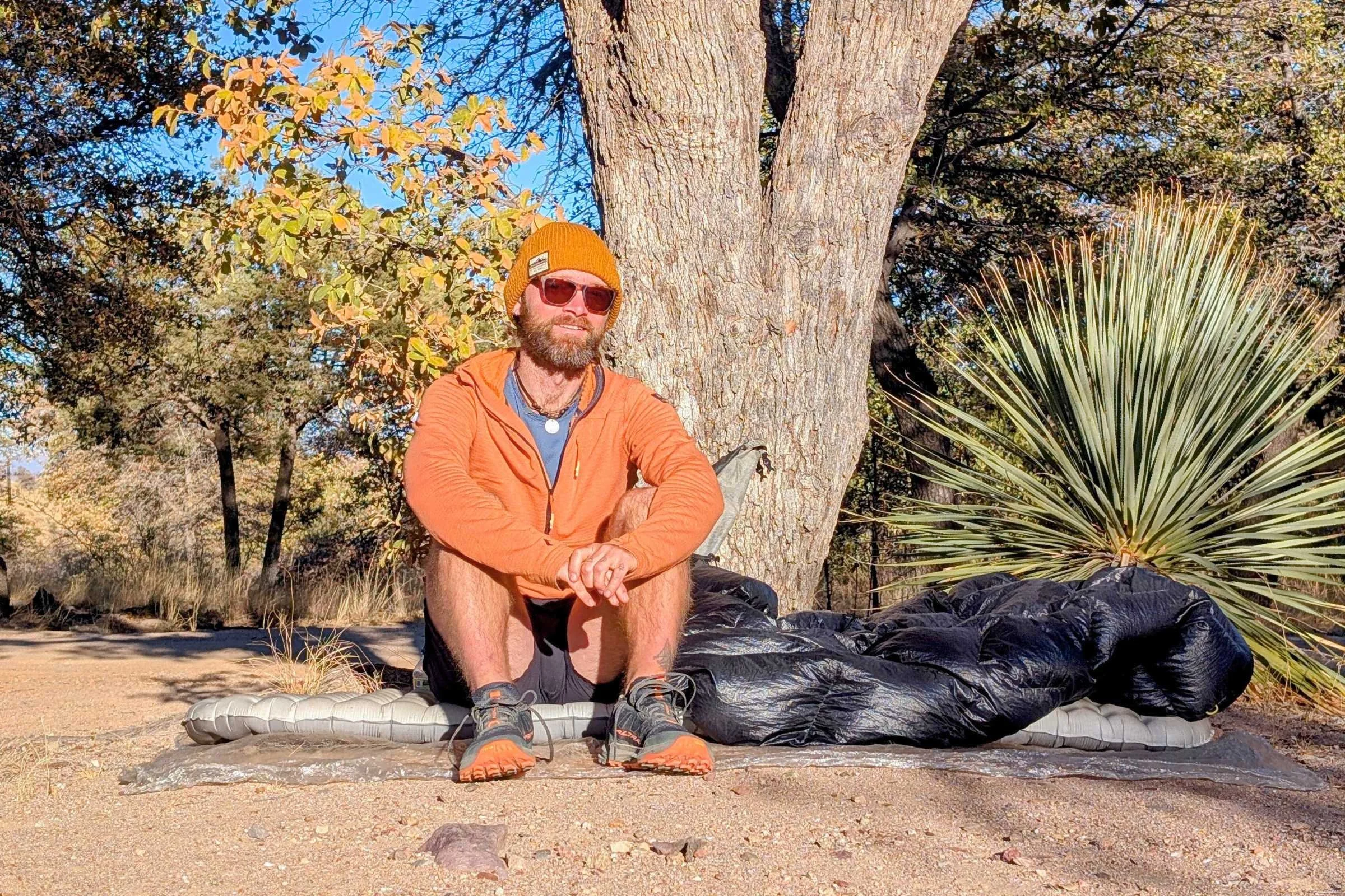 a man sitting on the nemo tensor elite sleeping pad on a sunny day