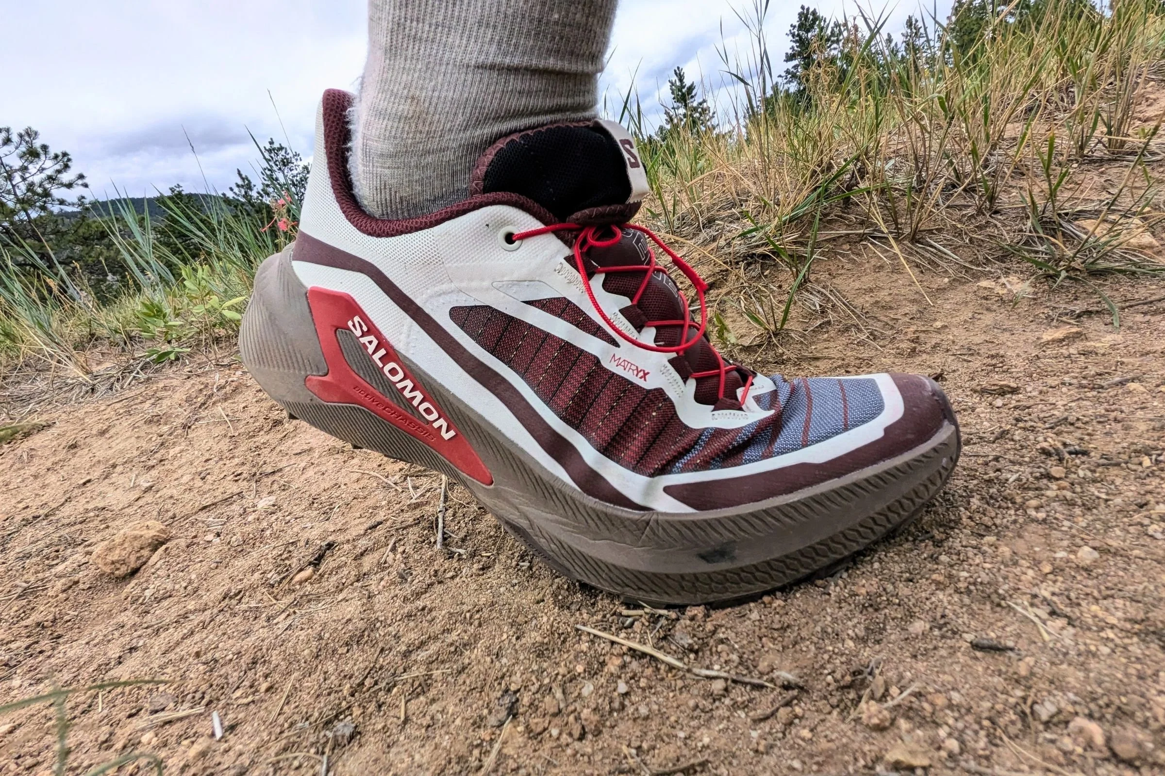 A close view Salomon Genesis 2 Trail Running Shoes on a dirt trail.
