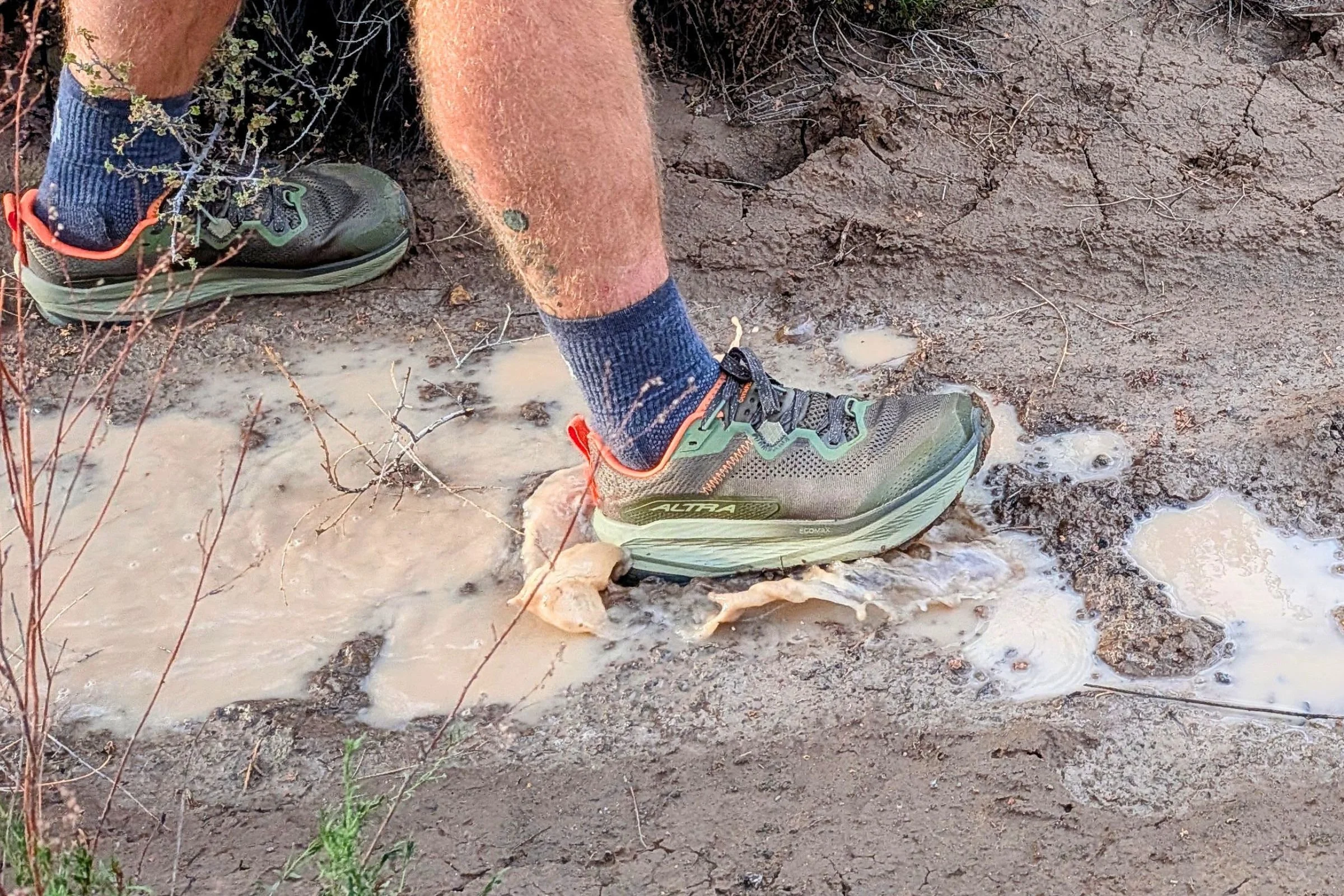 Man testing Altra Olympus 7 shoes in a puddle.