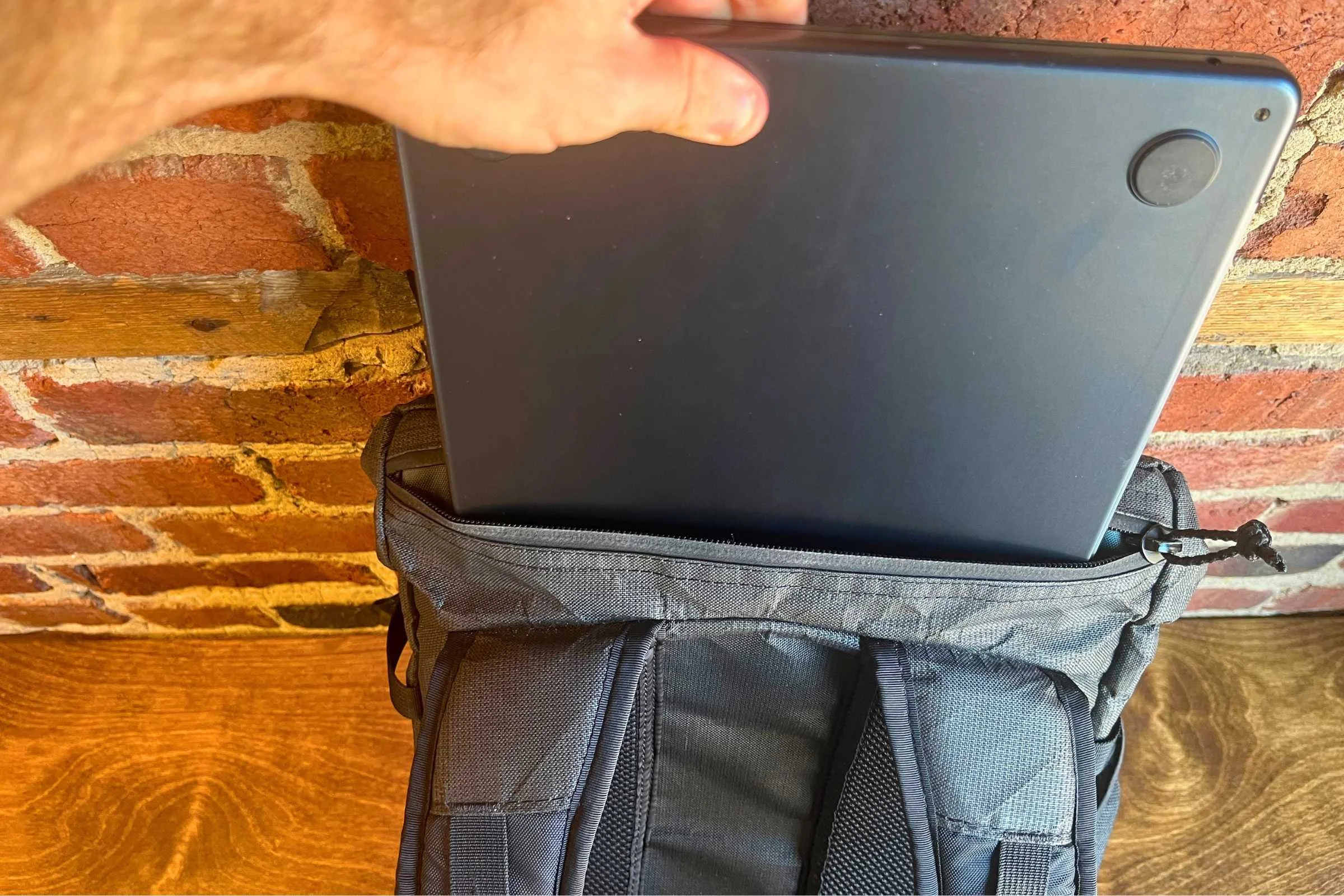 ULA Ultra Dragonfly 30L Adventure Travel Backpack shown with a person holding a laptop.