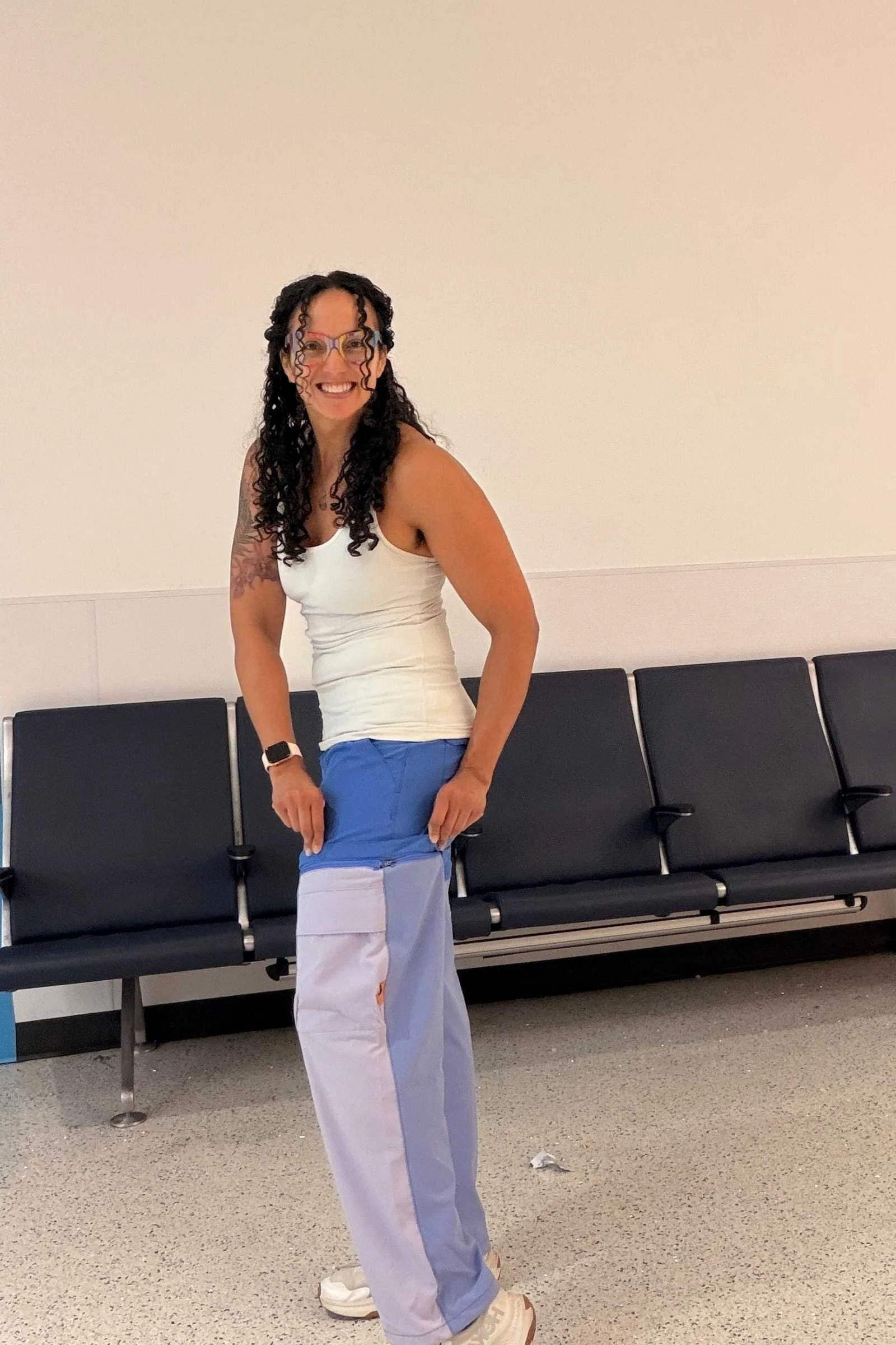 Woman wearing Cotopaxi Losdos Zip Off travel pants showing off left zip in an airport