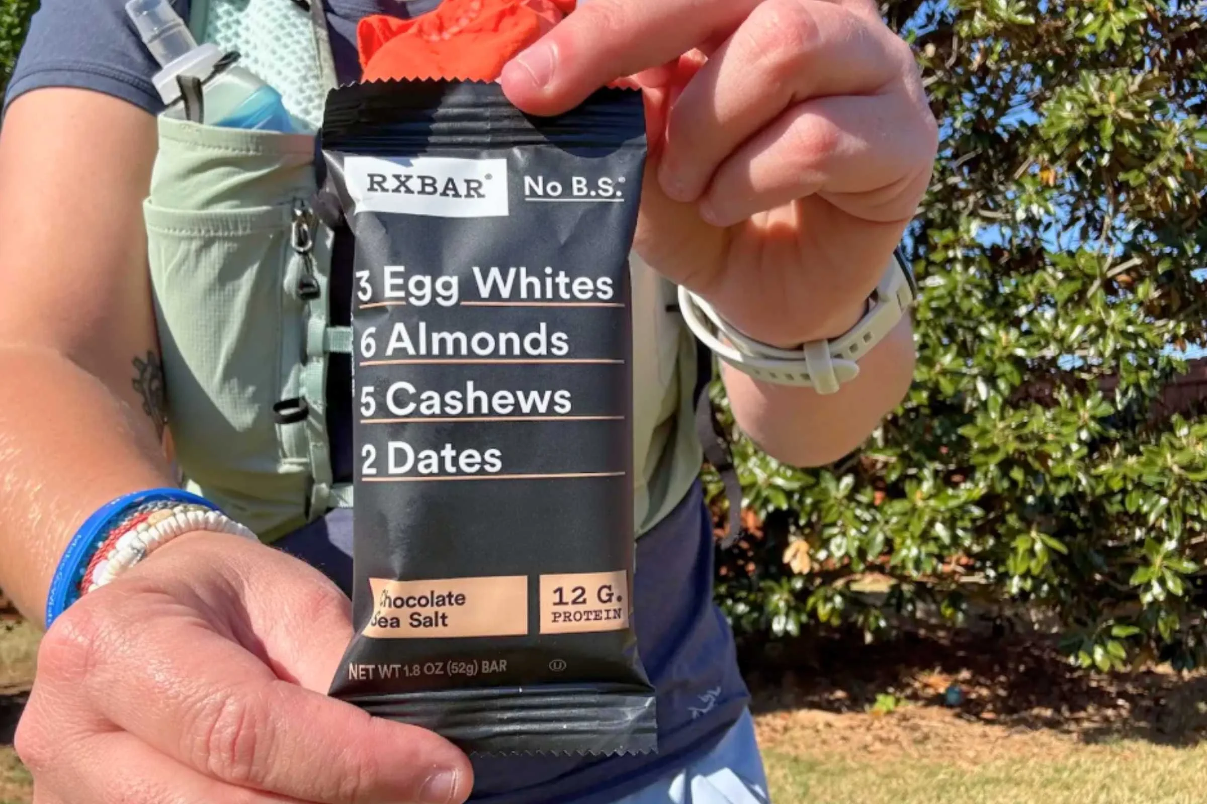 person holding a packaged RXBAR close to the camera