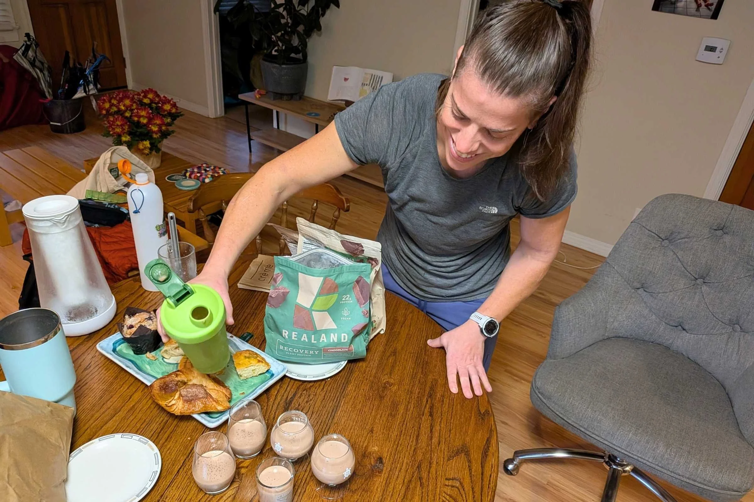 Woman pouring testing glasses of Realand protein powder