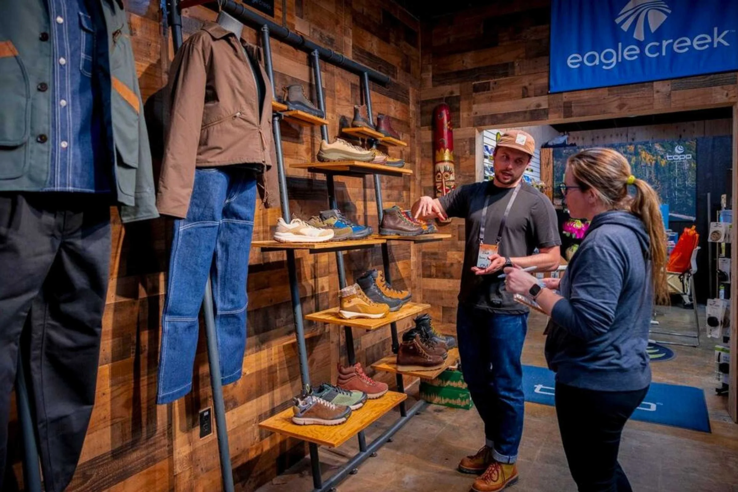 Sara checking out Eagle Creek travel gear and footwear at Outdoor Market Alliance Winter 2026
