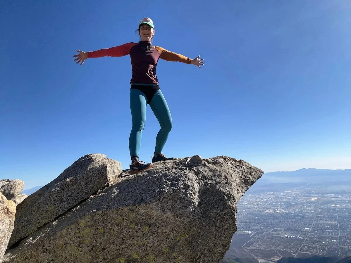 Person wearing Branwyn women's hiking underwear on rock outcropping with Los Angeles in far distance