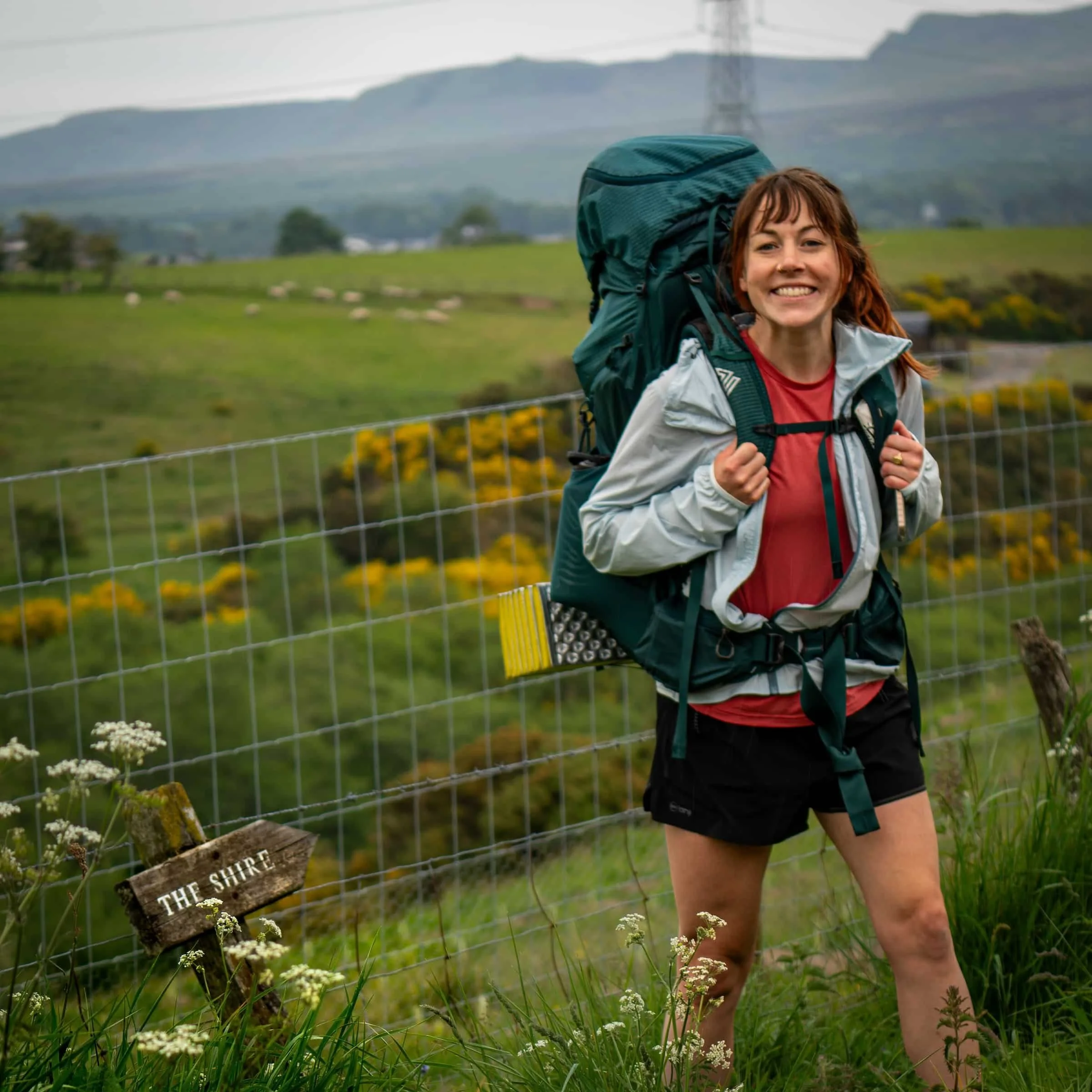 Author Becca Downs is smiling carrying a backpack