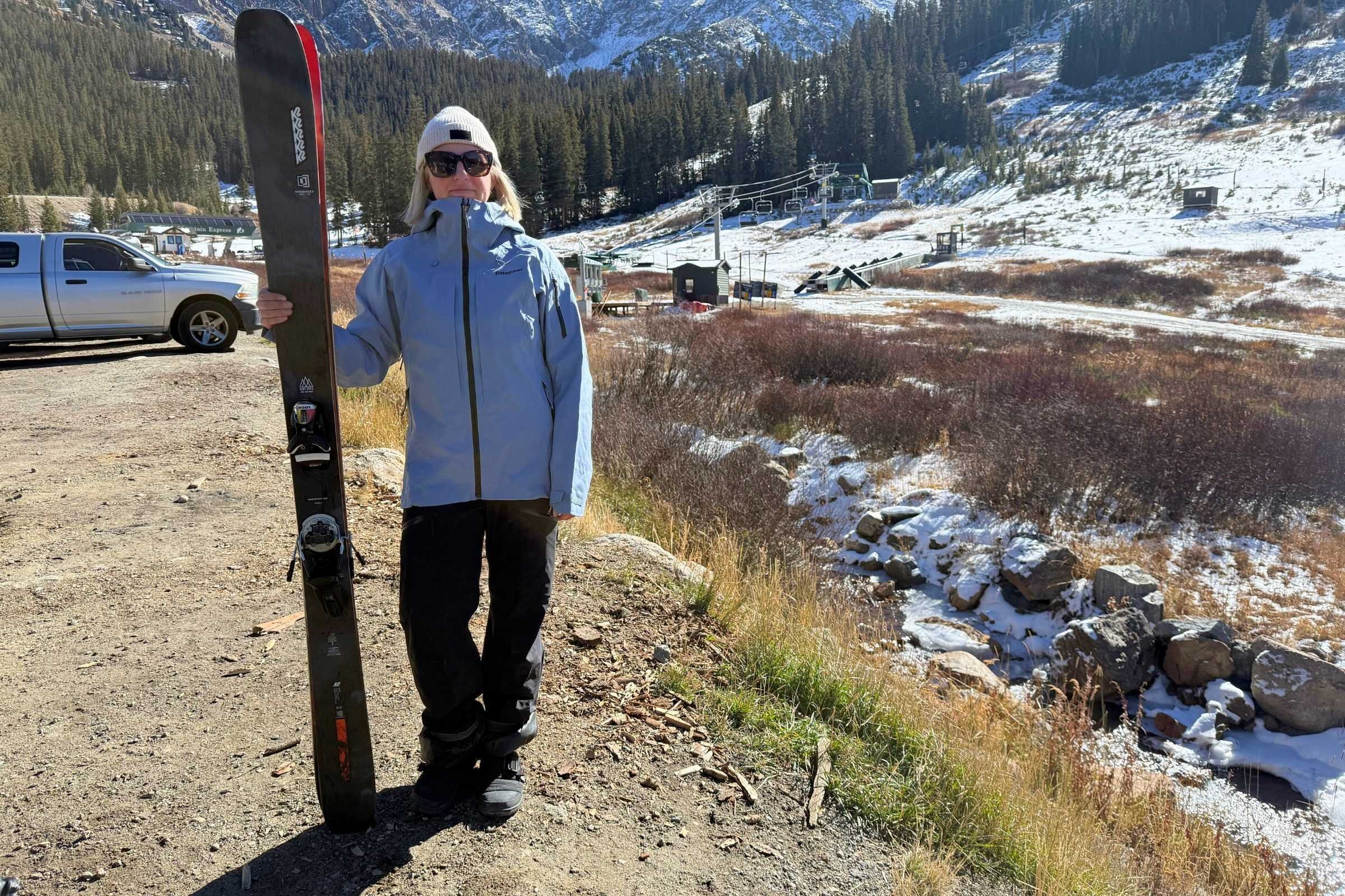 woman holding skis and wearing the Patagonia PowSlayer Jacket