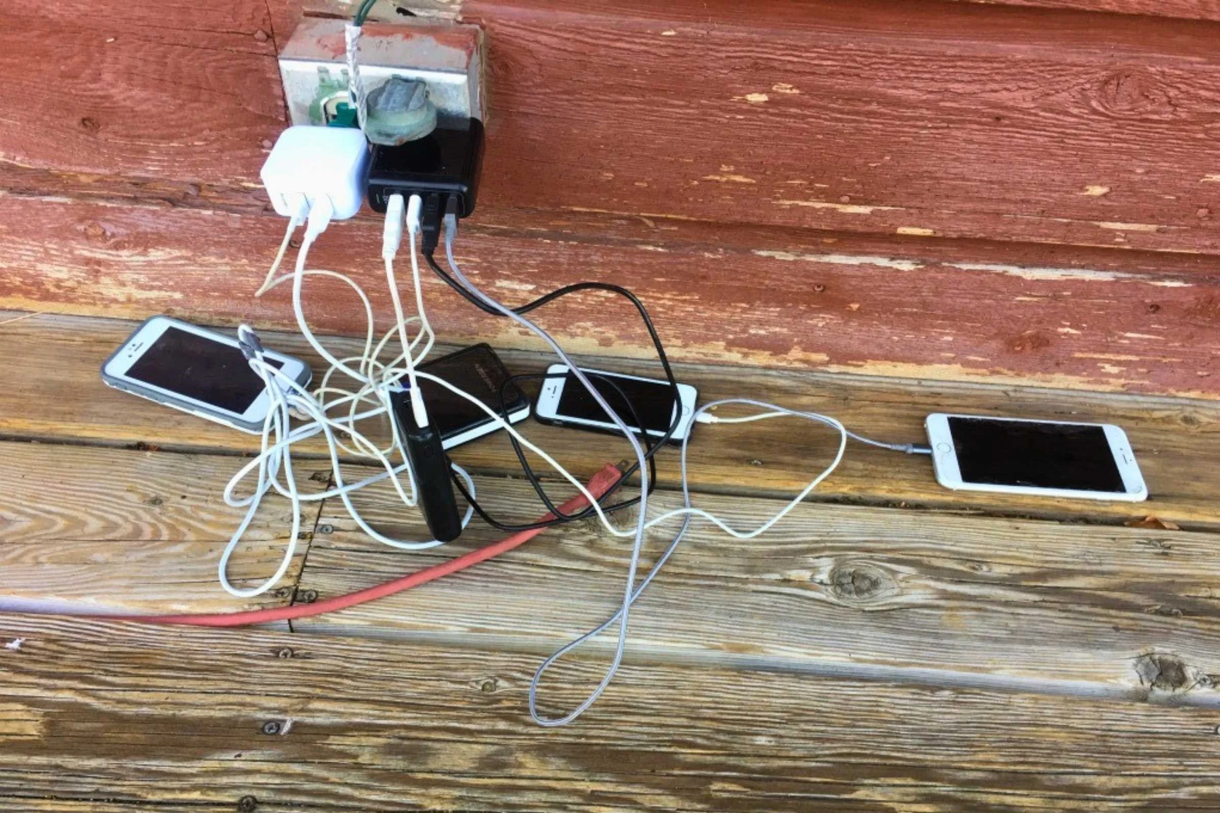Charging phone and power banks at an outdoor electrical outlet