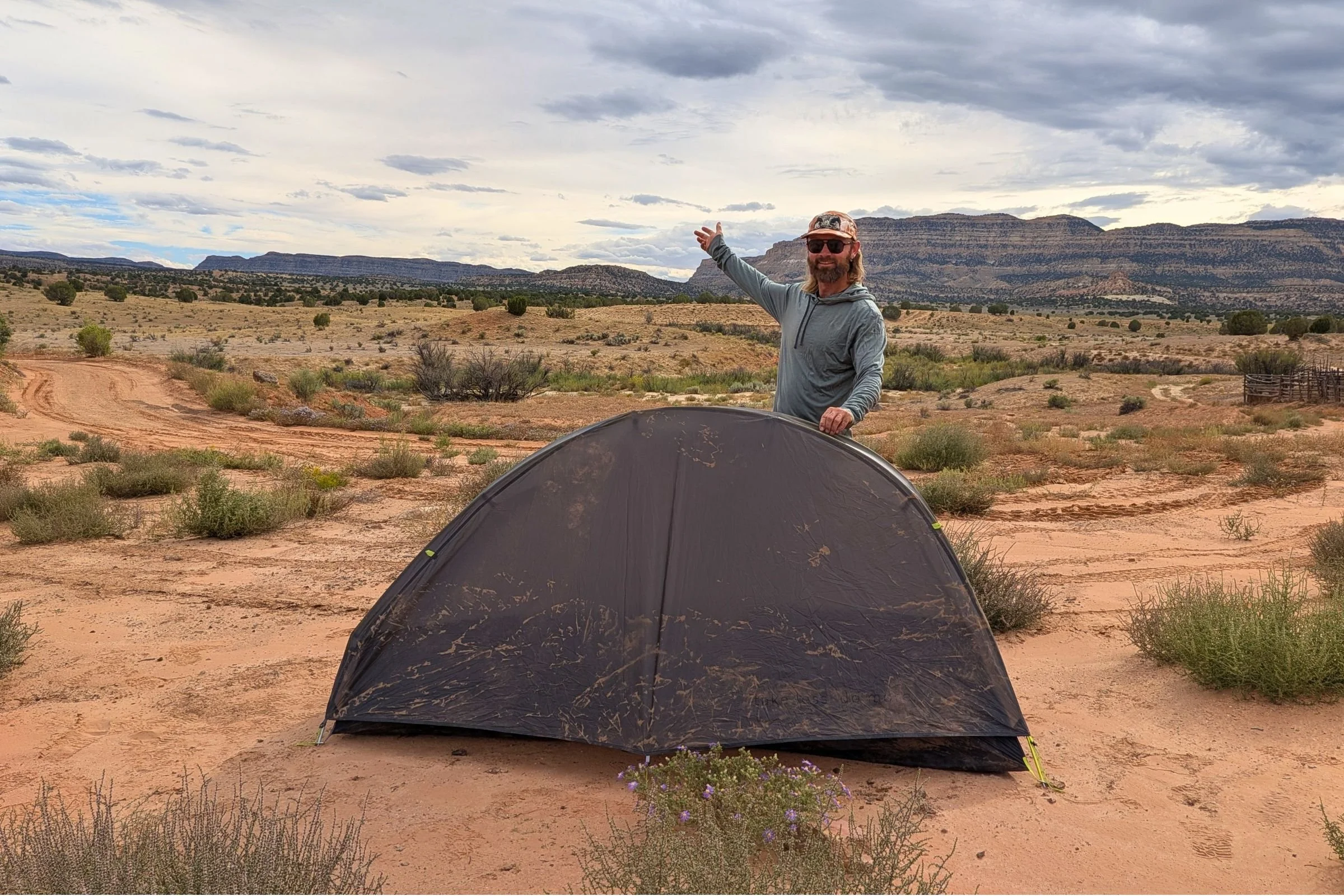 Gossamer Gear The Free pitched on sandy desert ground, with the author standing behind it.