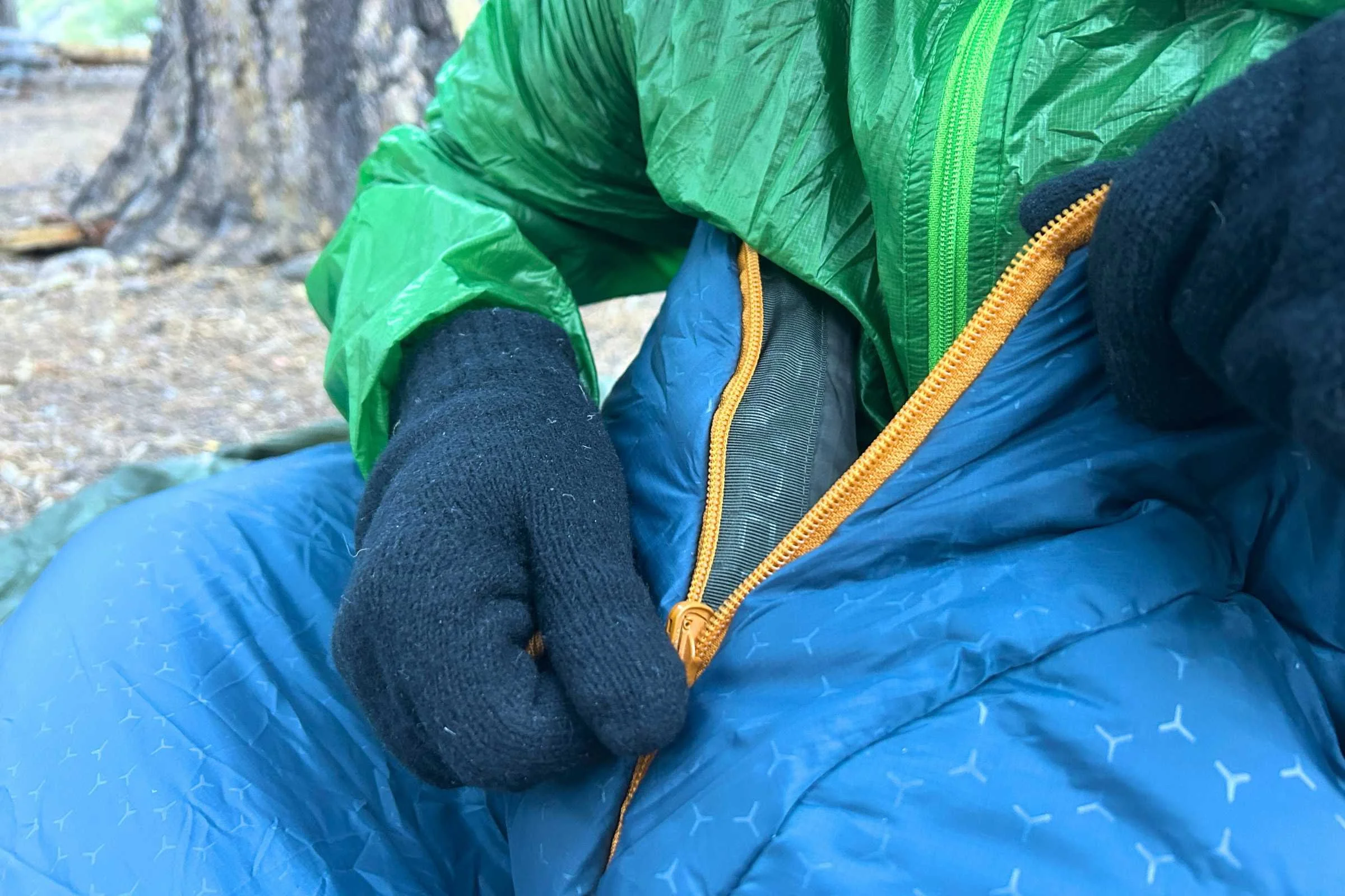 orange zipper being pulled on a blue exped deepsleep sleeping bag