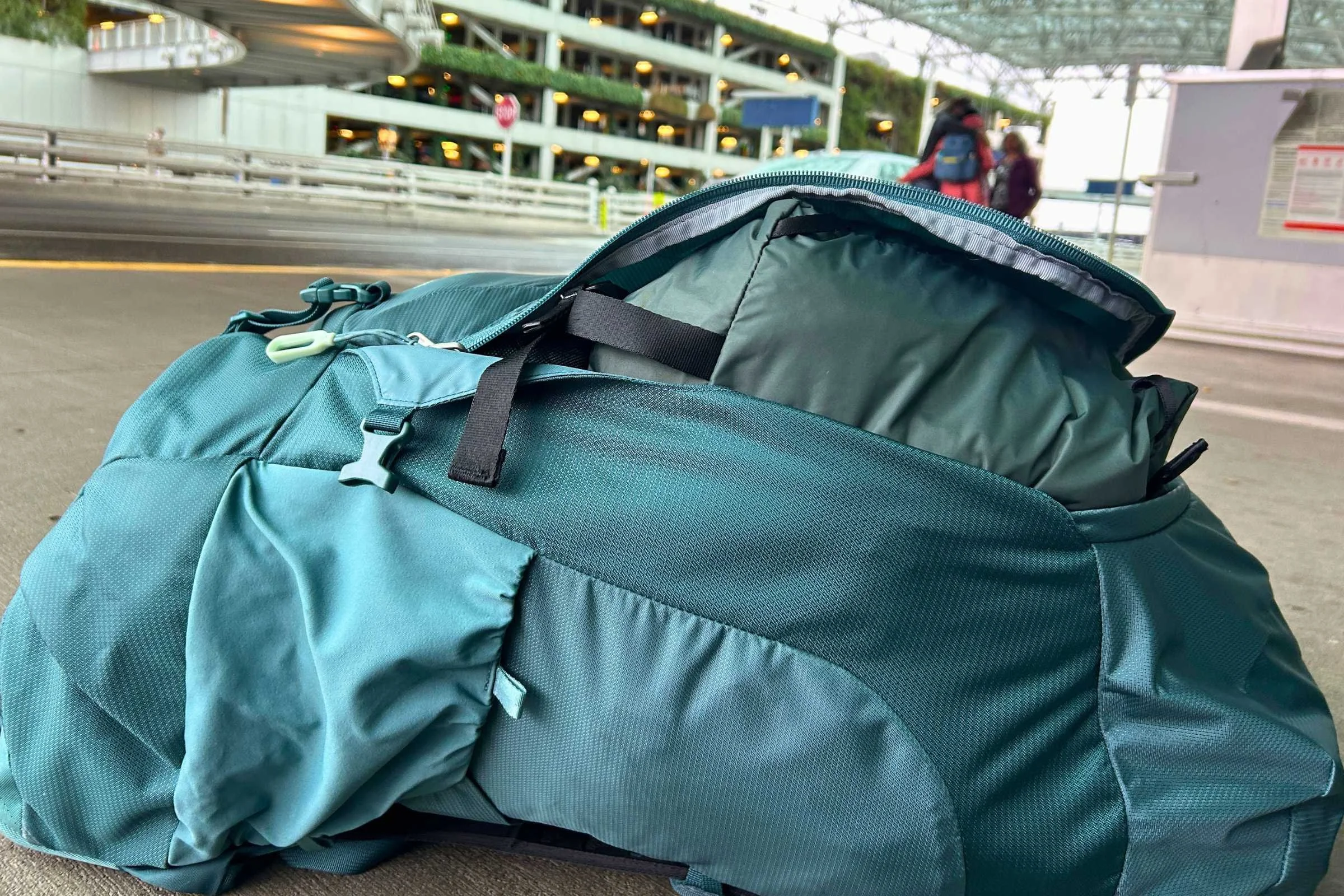 Large blue Osprey Fairview Trek 55 Travel Pack sitting on the ground.