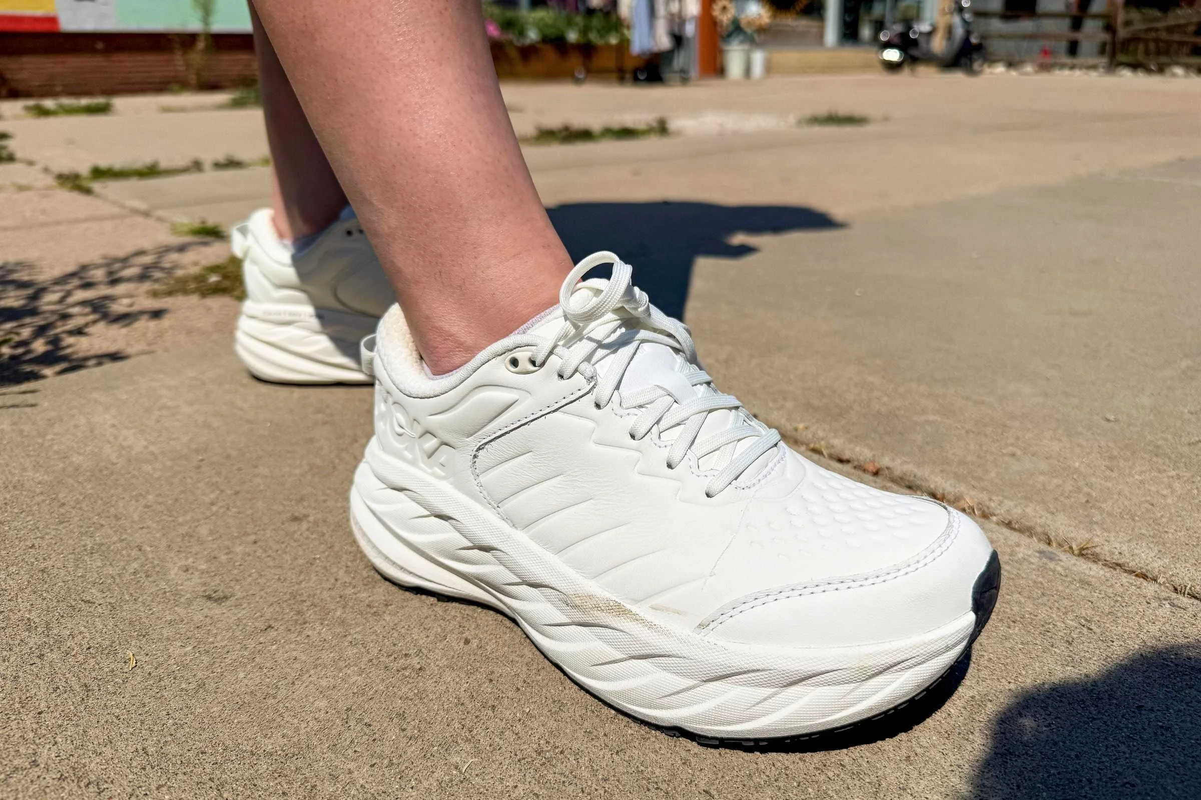 close-up of white hoka bondi sr shoe on sidewalk