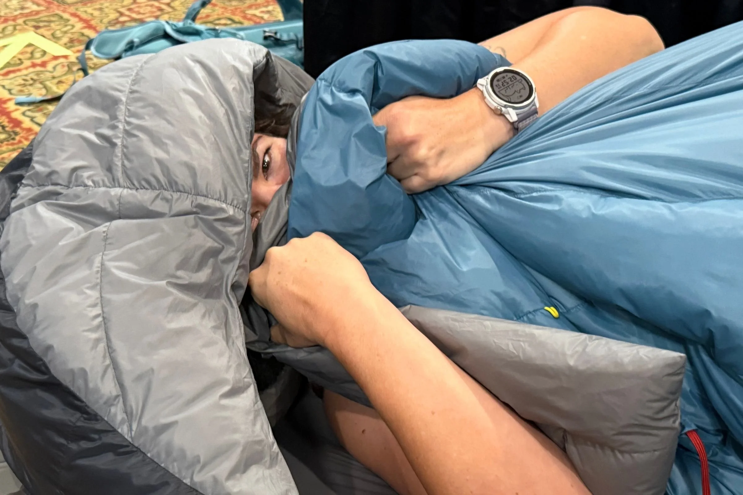 A woman rests inside a sleeping bag at the 2026 Outdoor Media Summit.