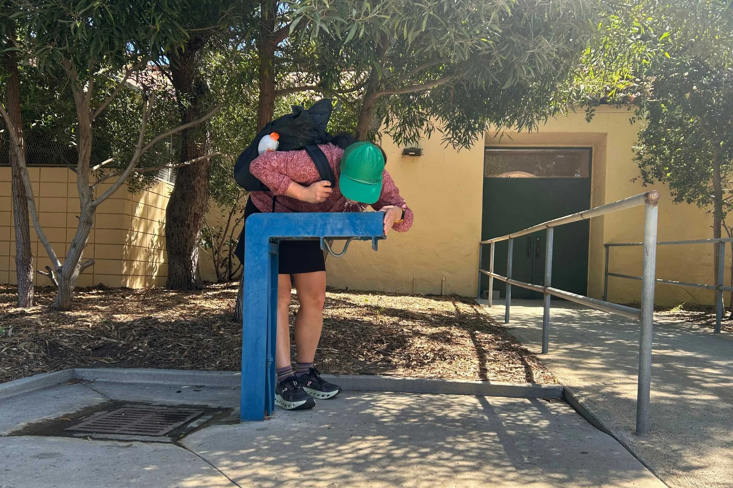 author wearing the ula ultra node 20l backpack while drinking from a public drinking fountain