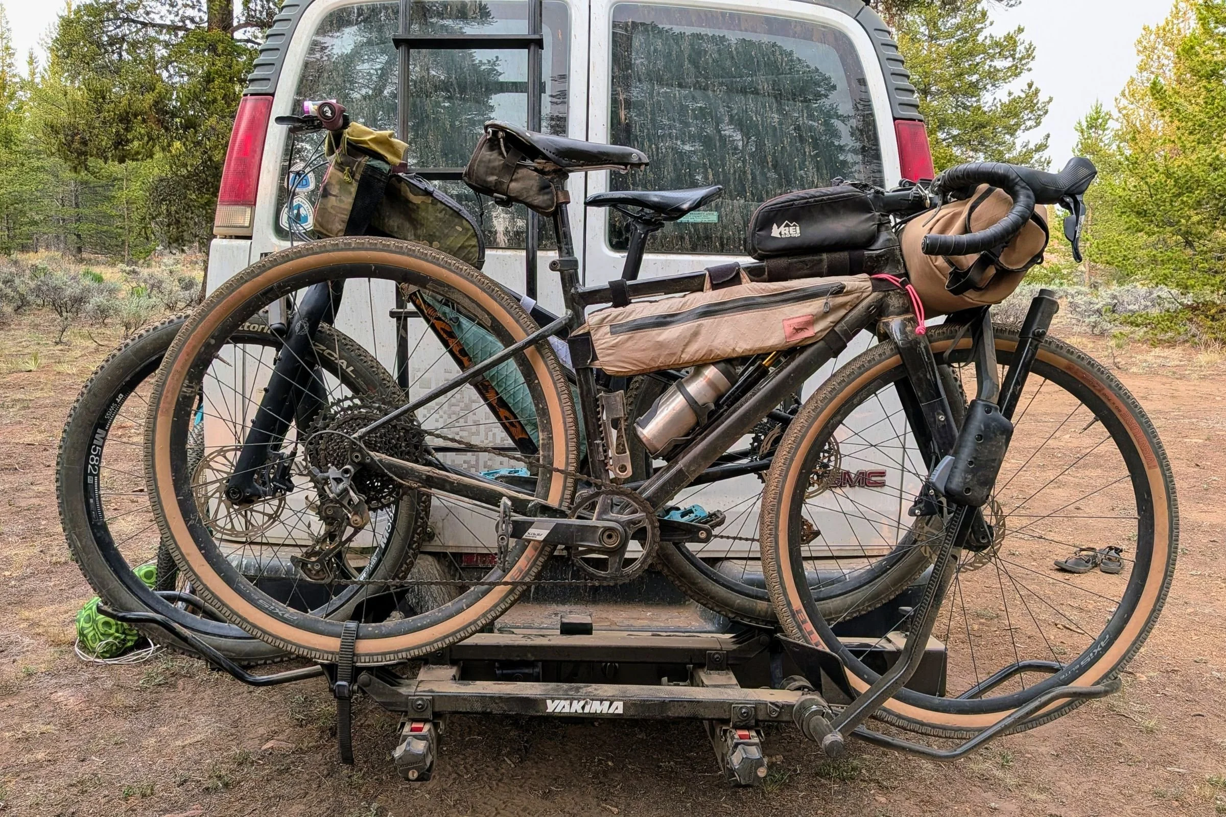 Two bikes are mounted on a Yakima EXO DoubleUp 2-Bike Hitch Rack attached to the back of a van.