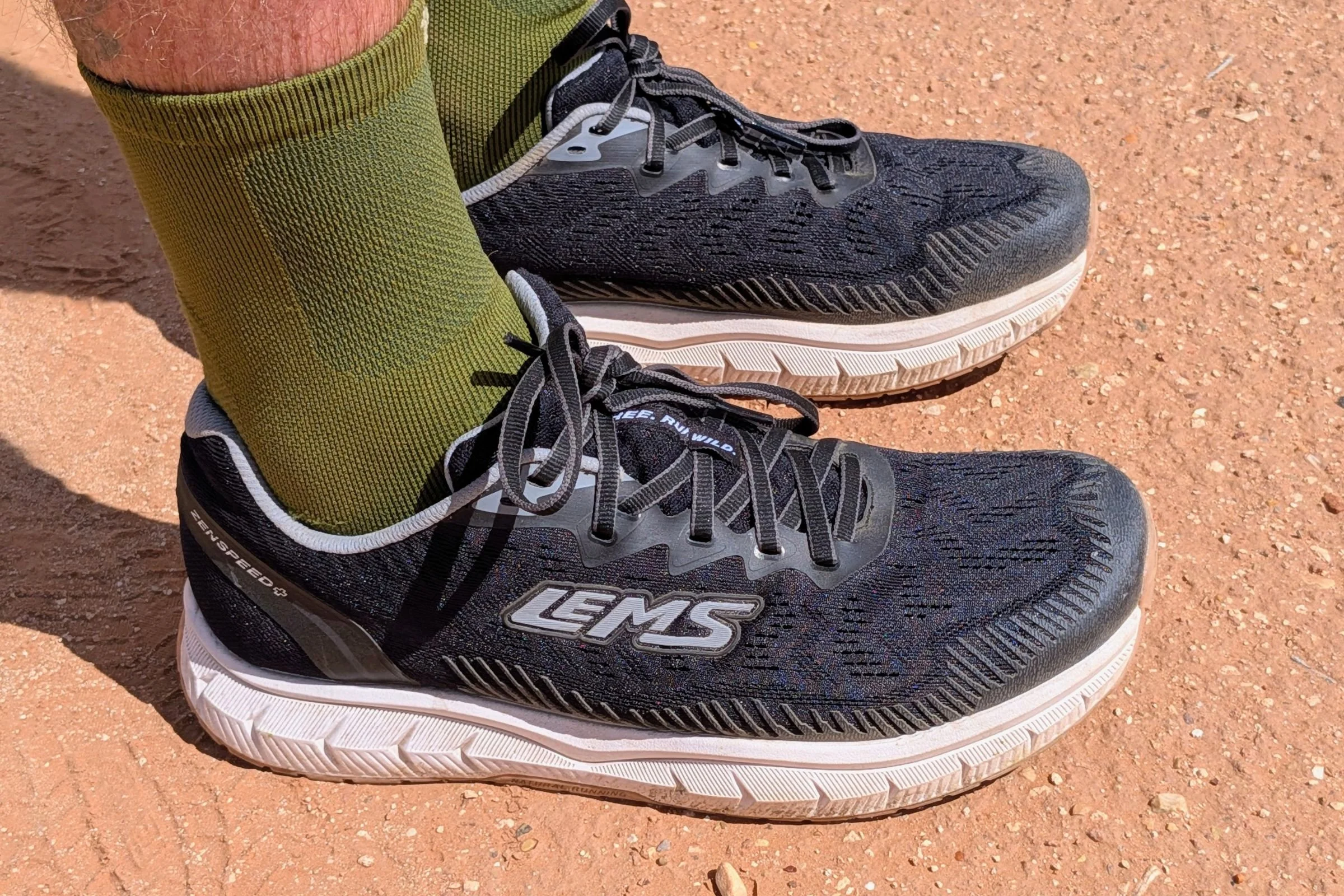 Close-up of black Lems ZENSPEED+ shoes worn by a runner.