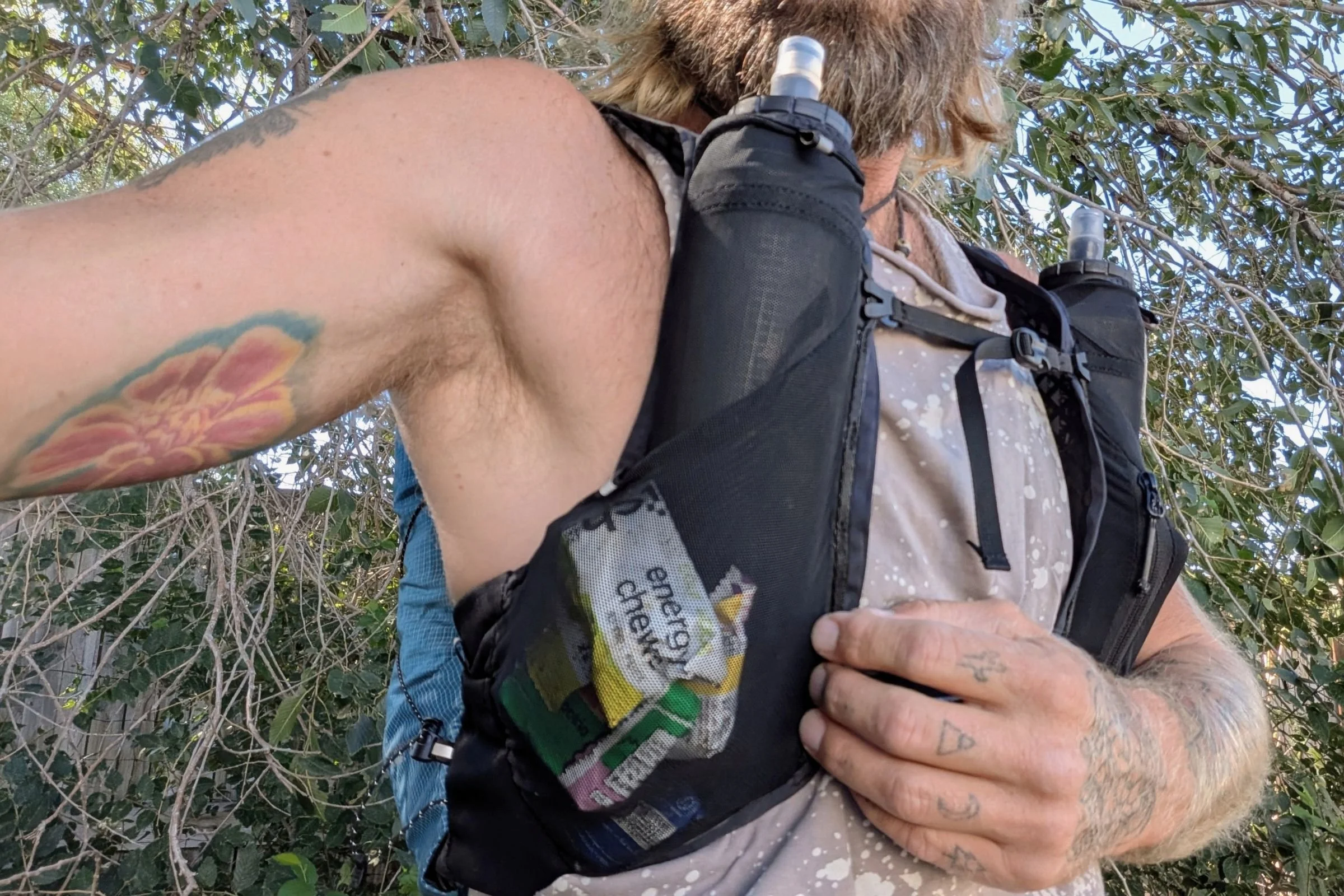 A man showing the shoulder strap pocket layout on the Black Diamond Distance 15 pack